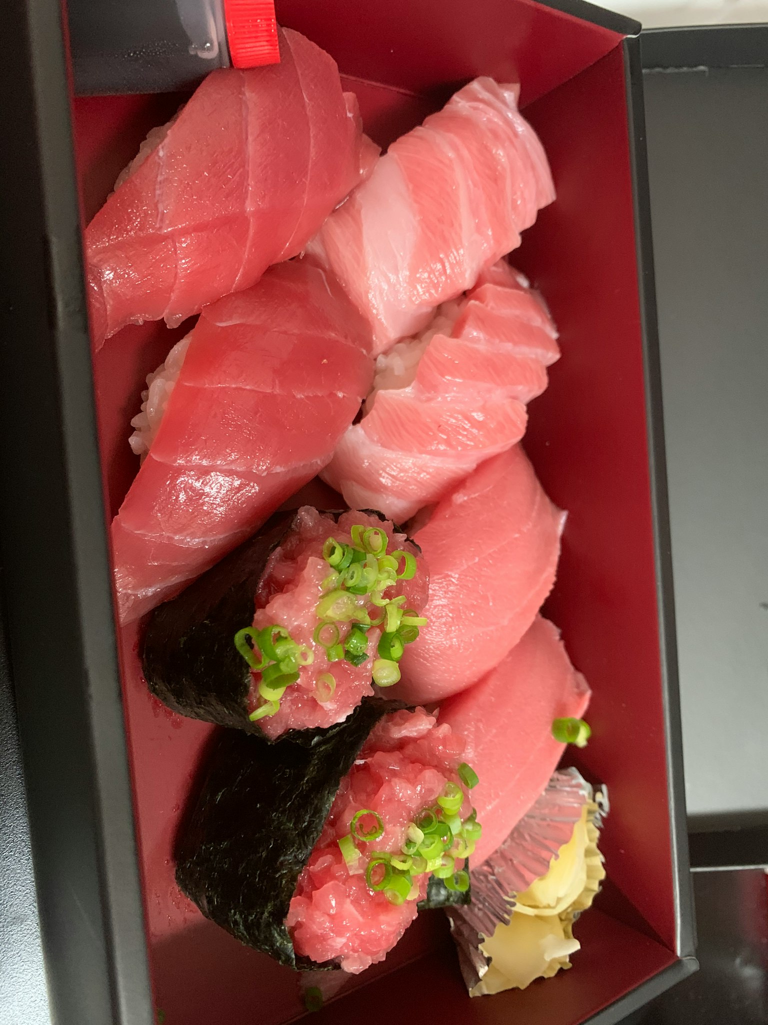 Un assortiment de sushi frais présenté dans une boîte rouge