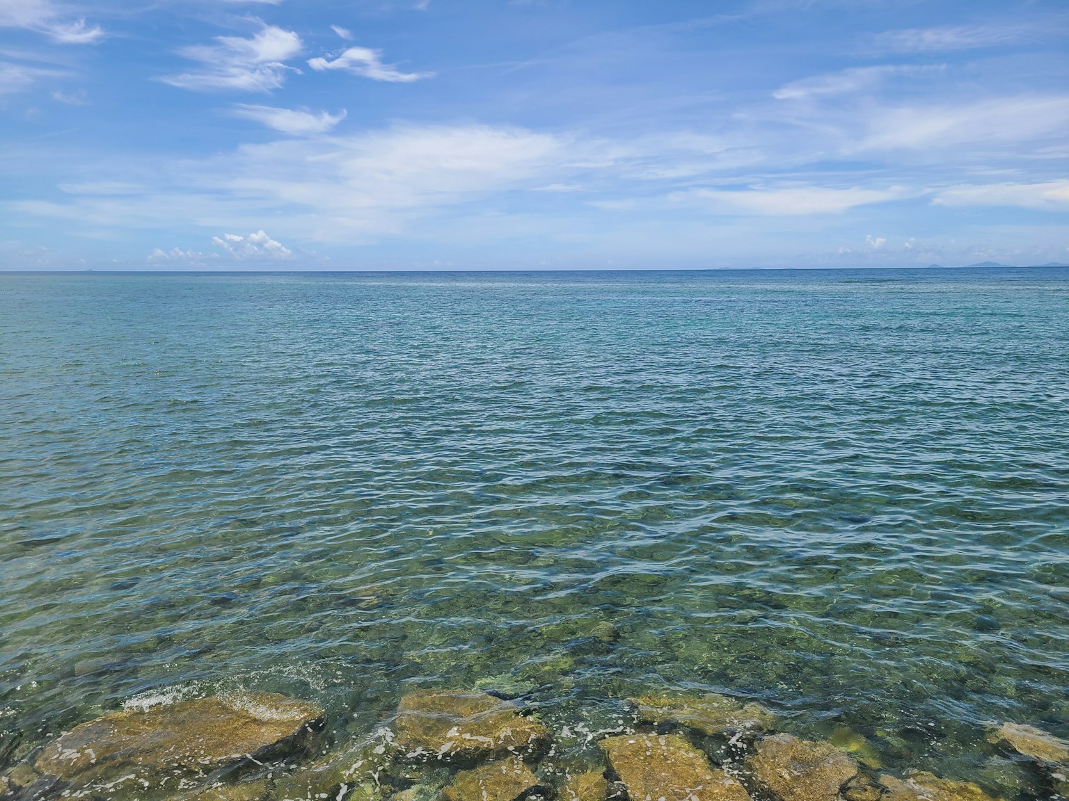 Beautiful landscape of blue sea and sky with visible rocky shore