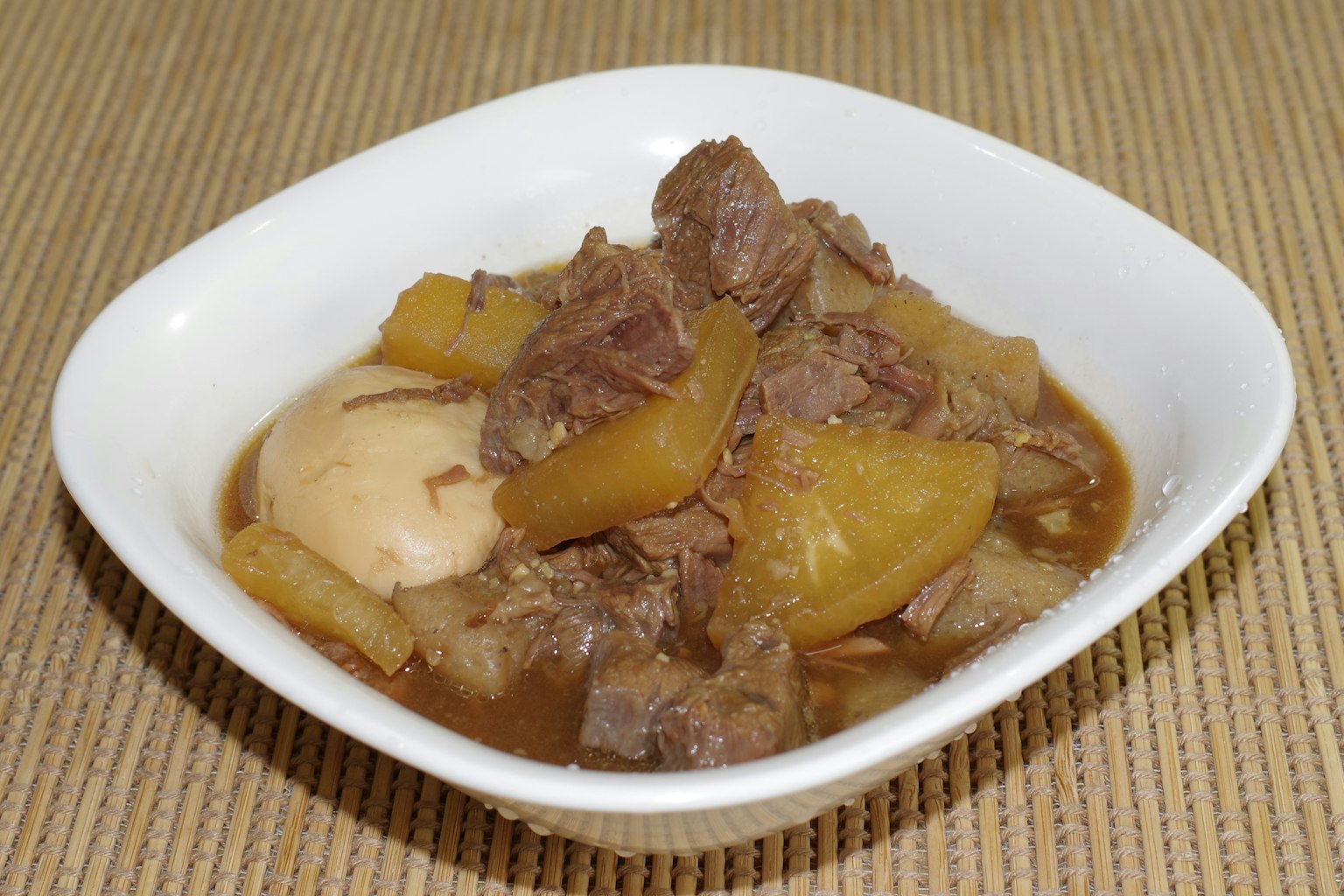 Plat de viande et de légumes braisés servi dans un bol blanc