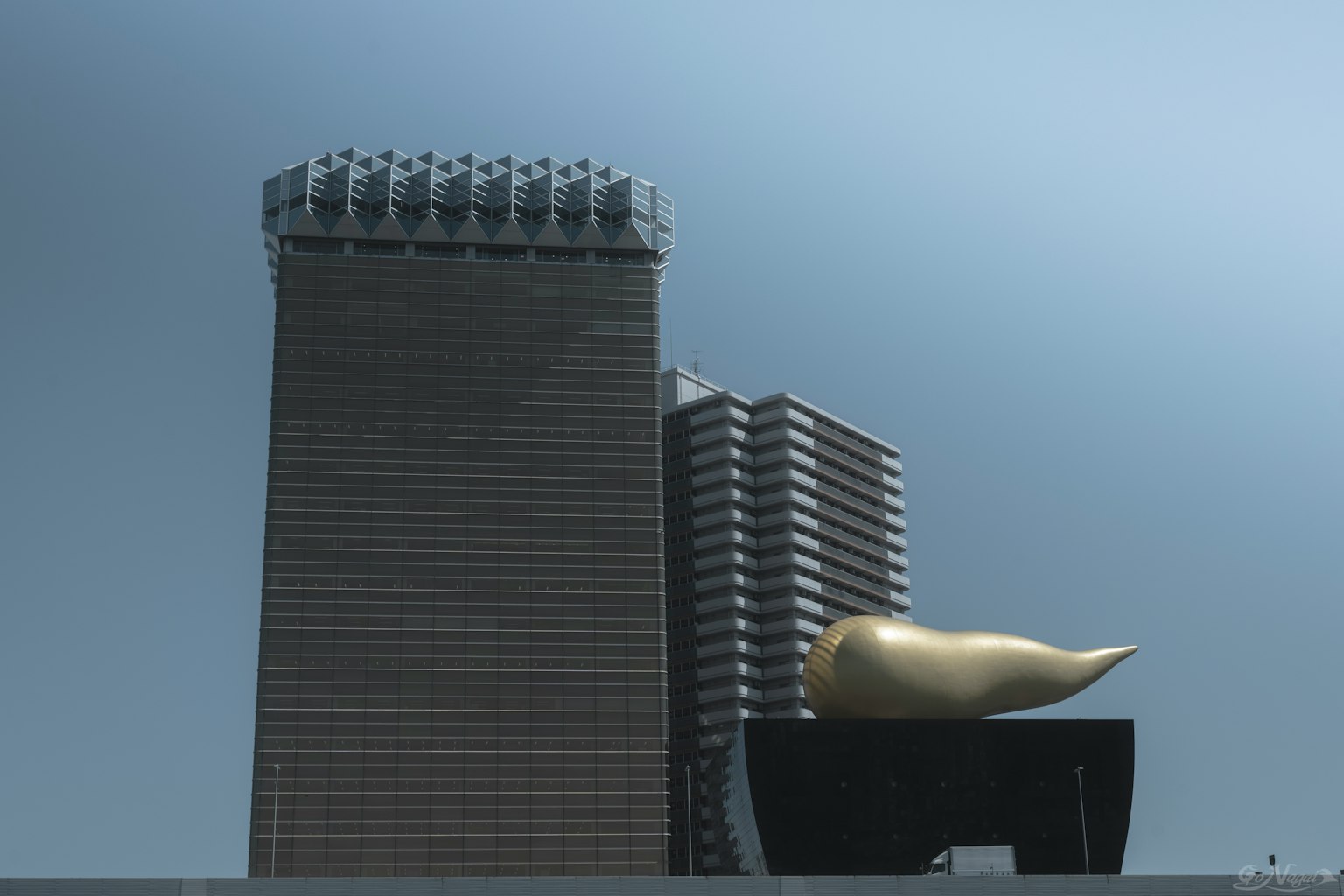 Paisaje urbano con un rascacielos y una escultura dorada