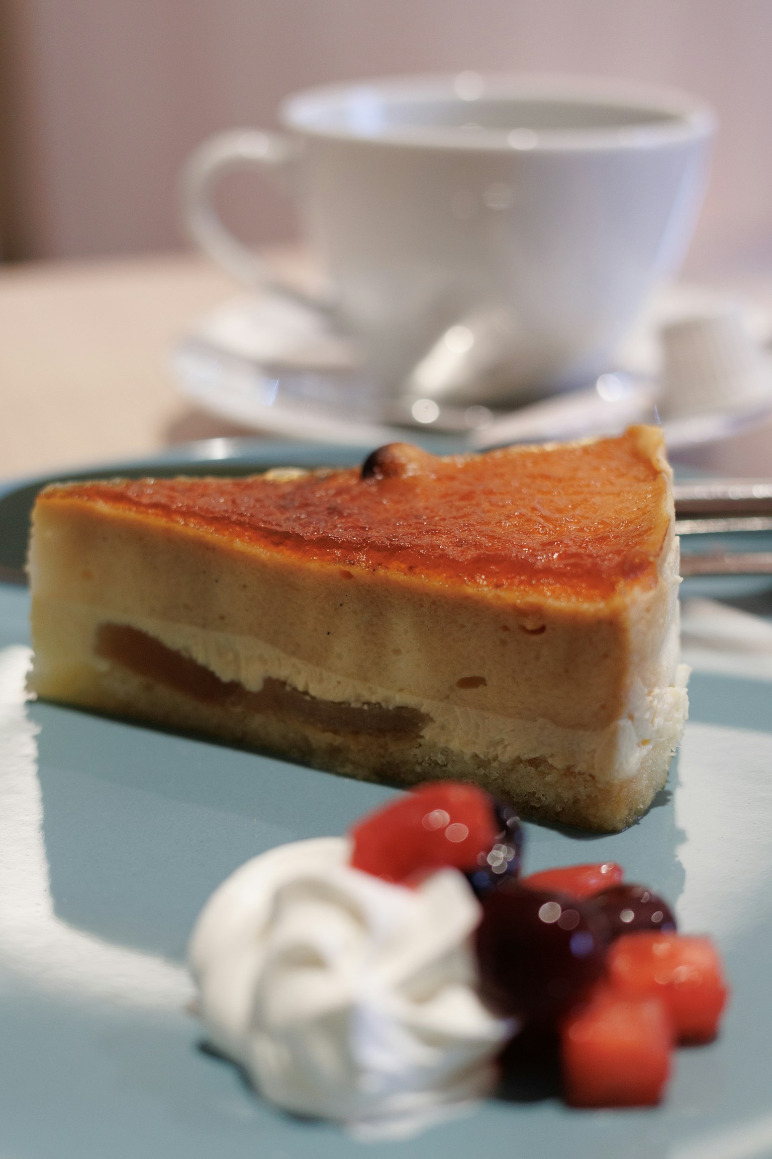 Deliciosa rebanada de pastel con frutas y crema batida al lado