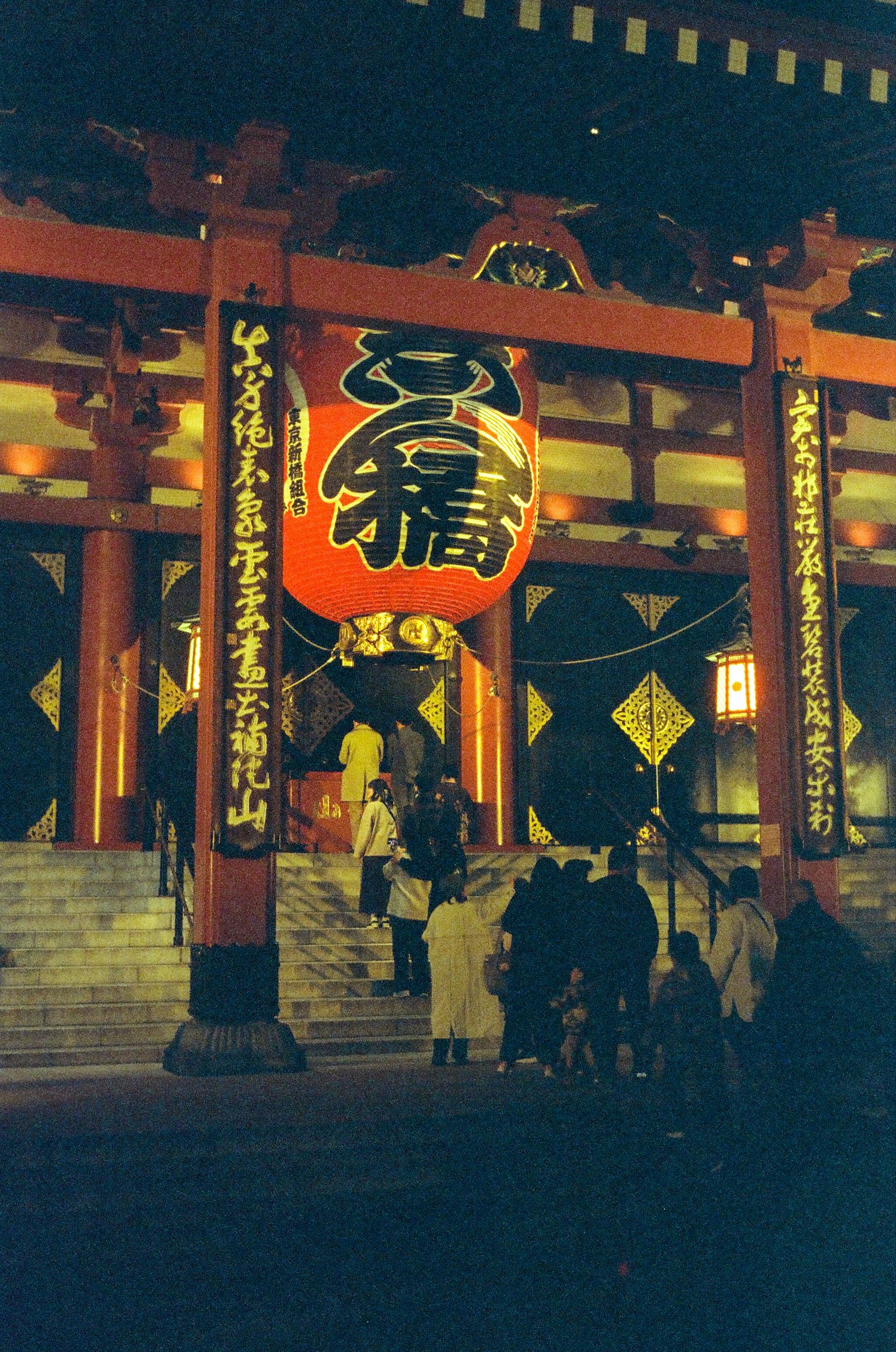 Una vista impressionante di un torii rosso e di una grande lanterna di notte in un santuario