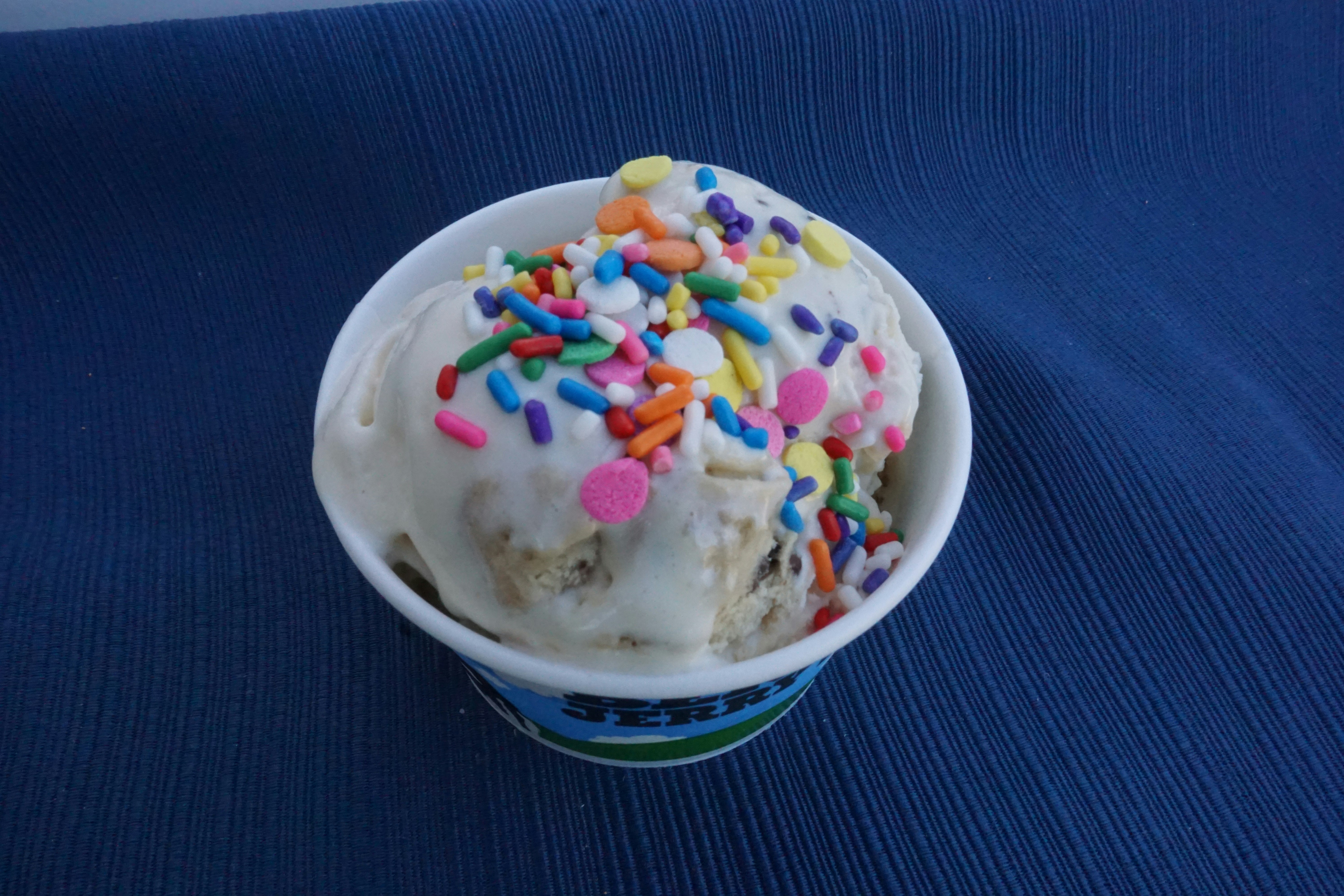 Helado en taza con chispas de colores sobre fondo azul