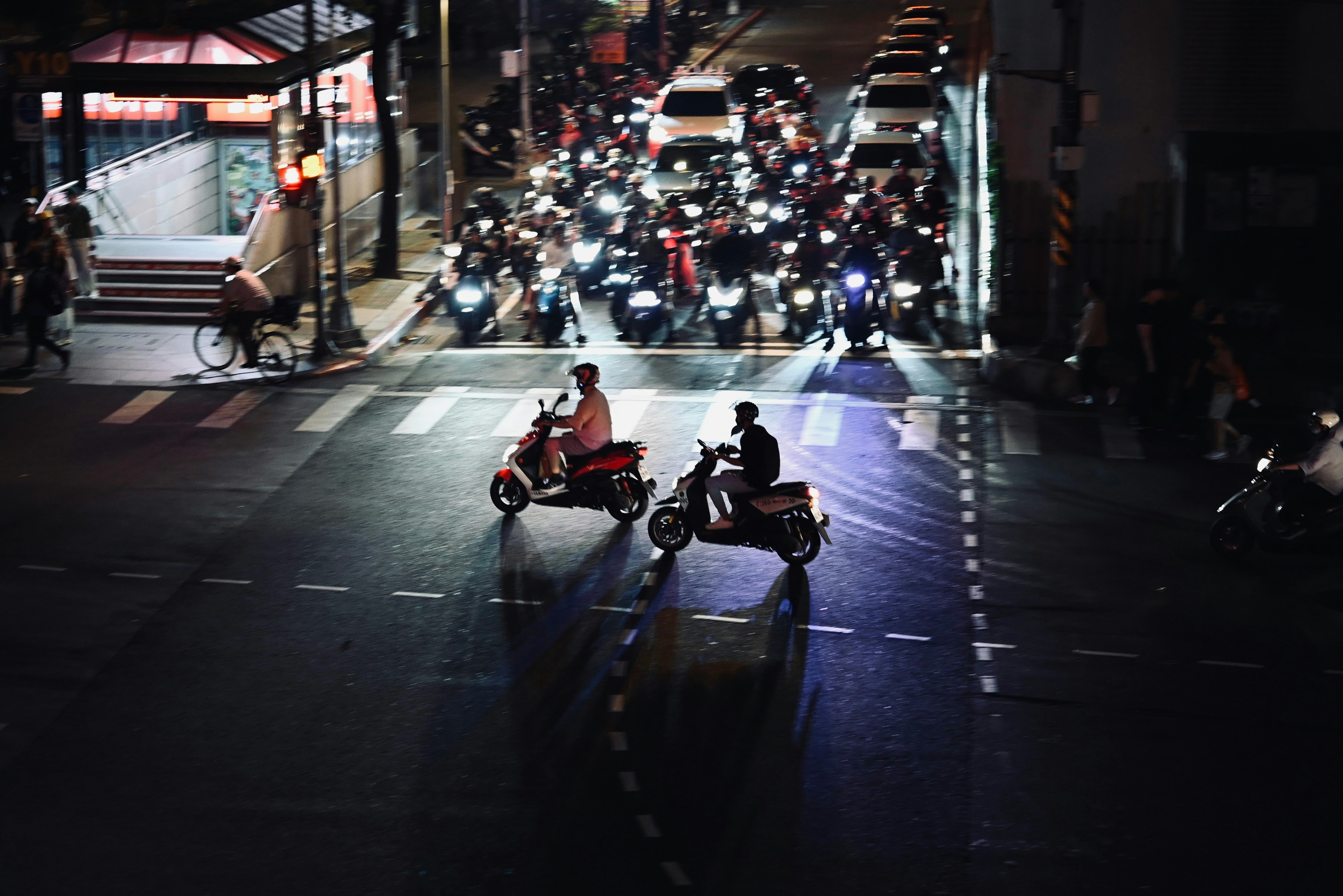 夜の街道を走る機車の列とネオンの光が反射する路面