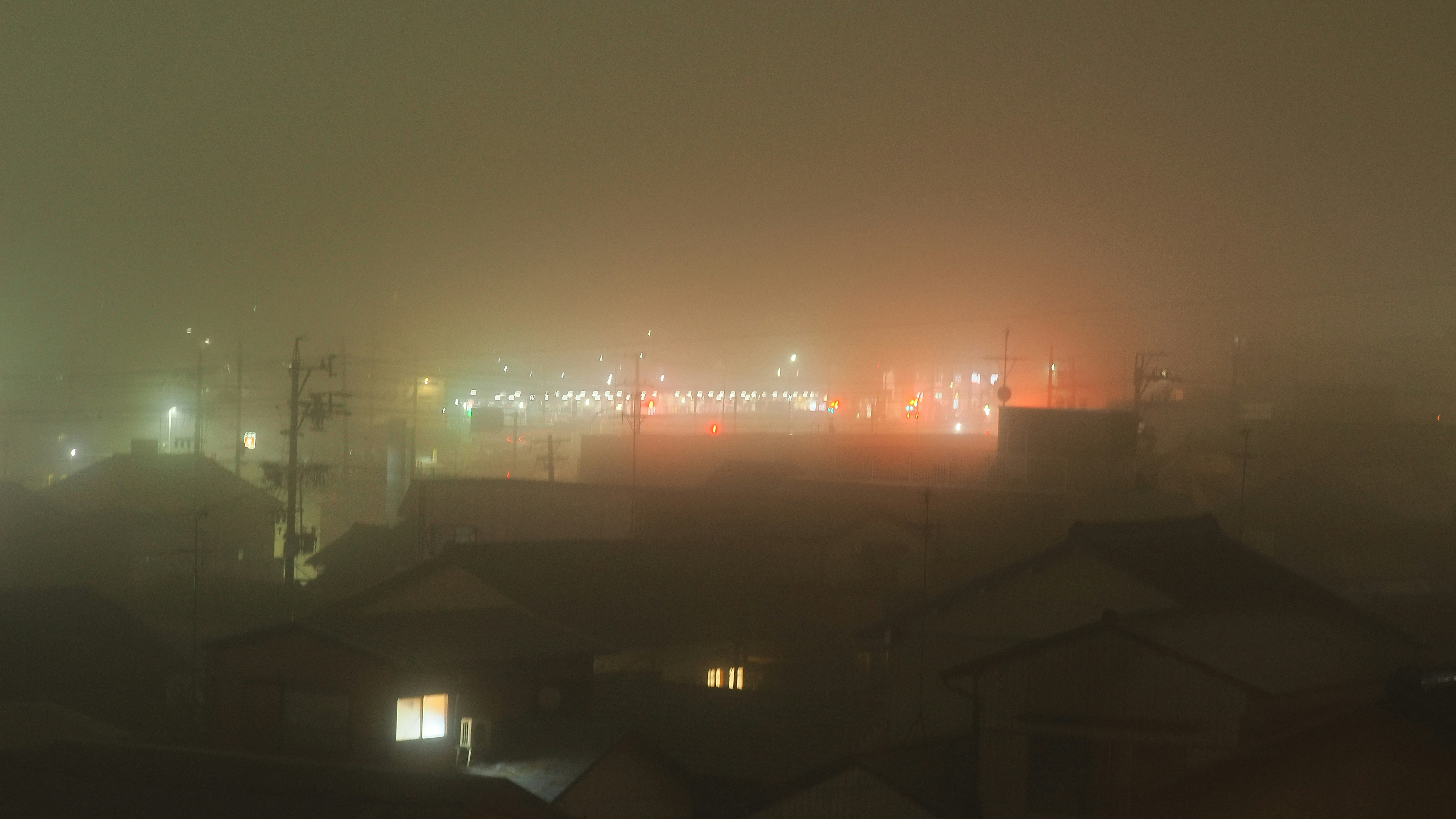 霧の夜に街灯が灯る住宅街の遠景