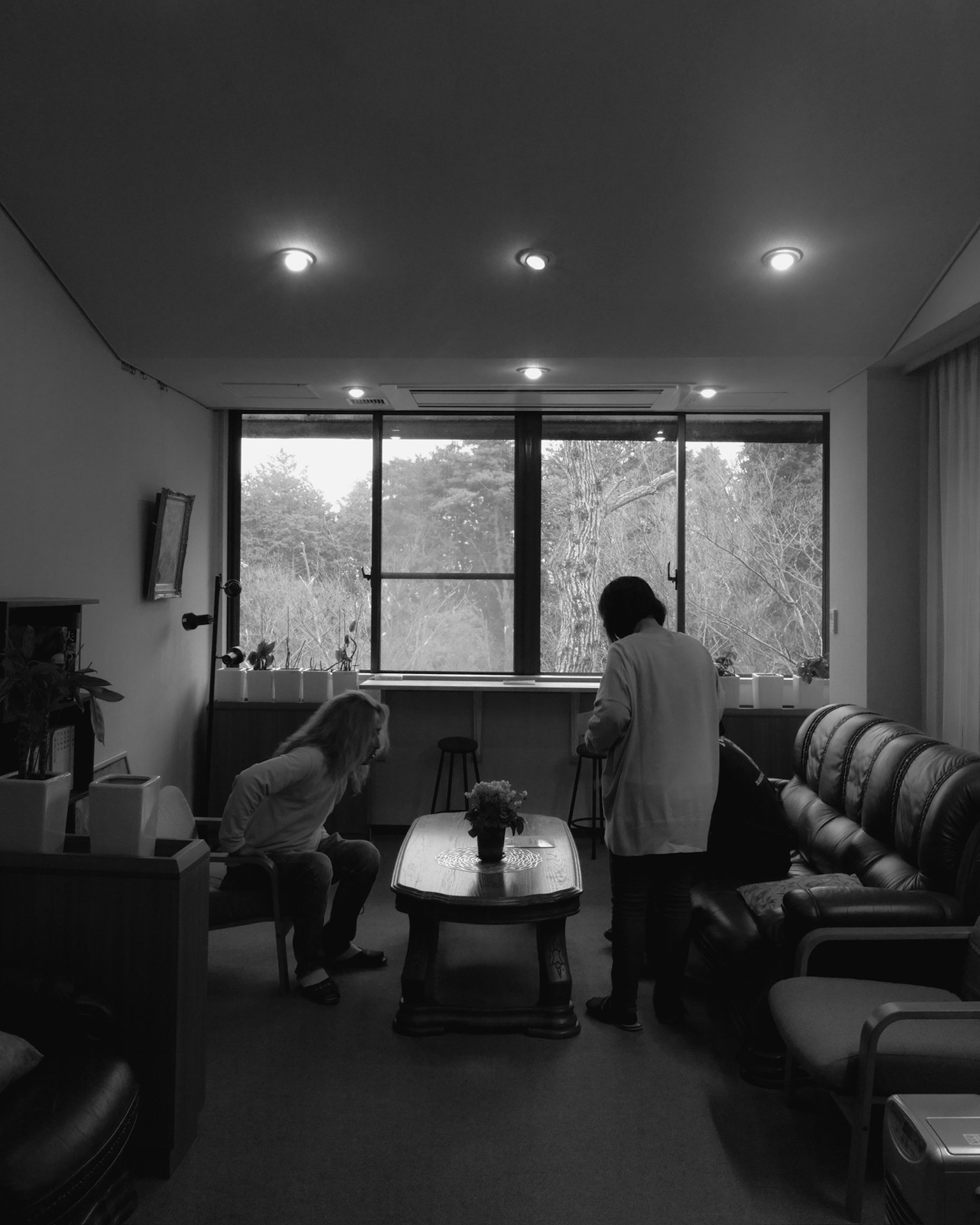 สองคนในสำนักงานที่สว่างสดใสมีปฏิสัมพันธ์รอบโต๊ะ