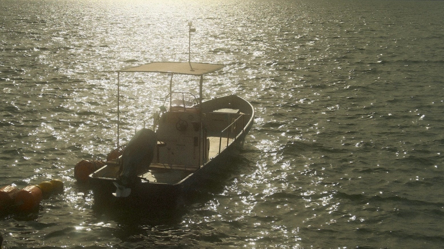 夕暮れの水面を進む小型ボート