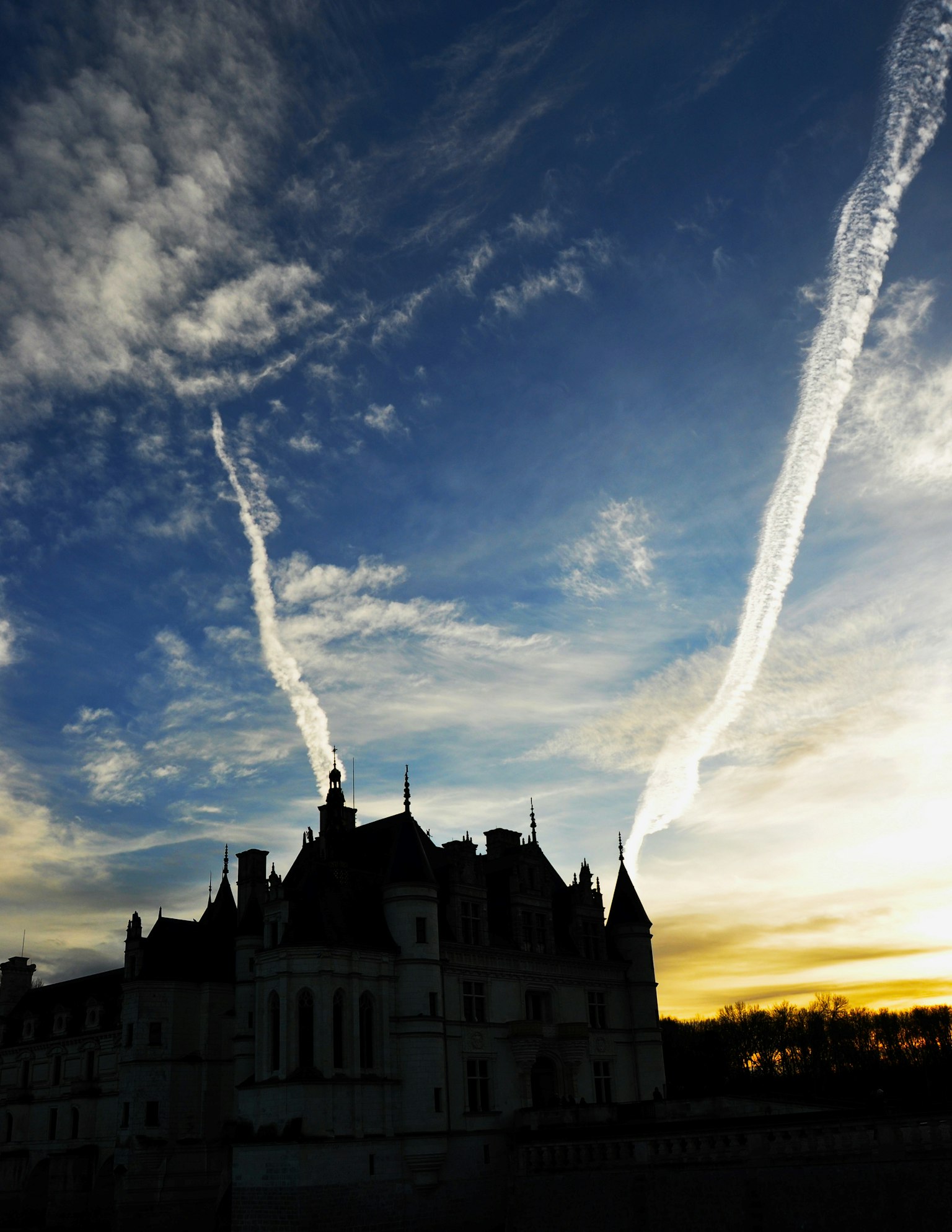 Silhouette eines Schlosses vor einem atemberaubenden Sonnenuntergang mit Wolkenstreifen