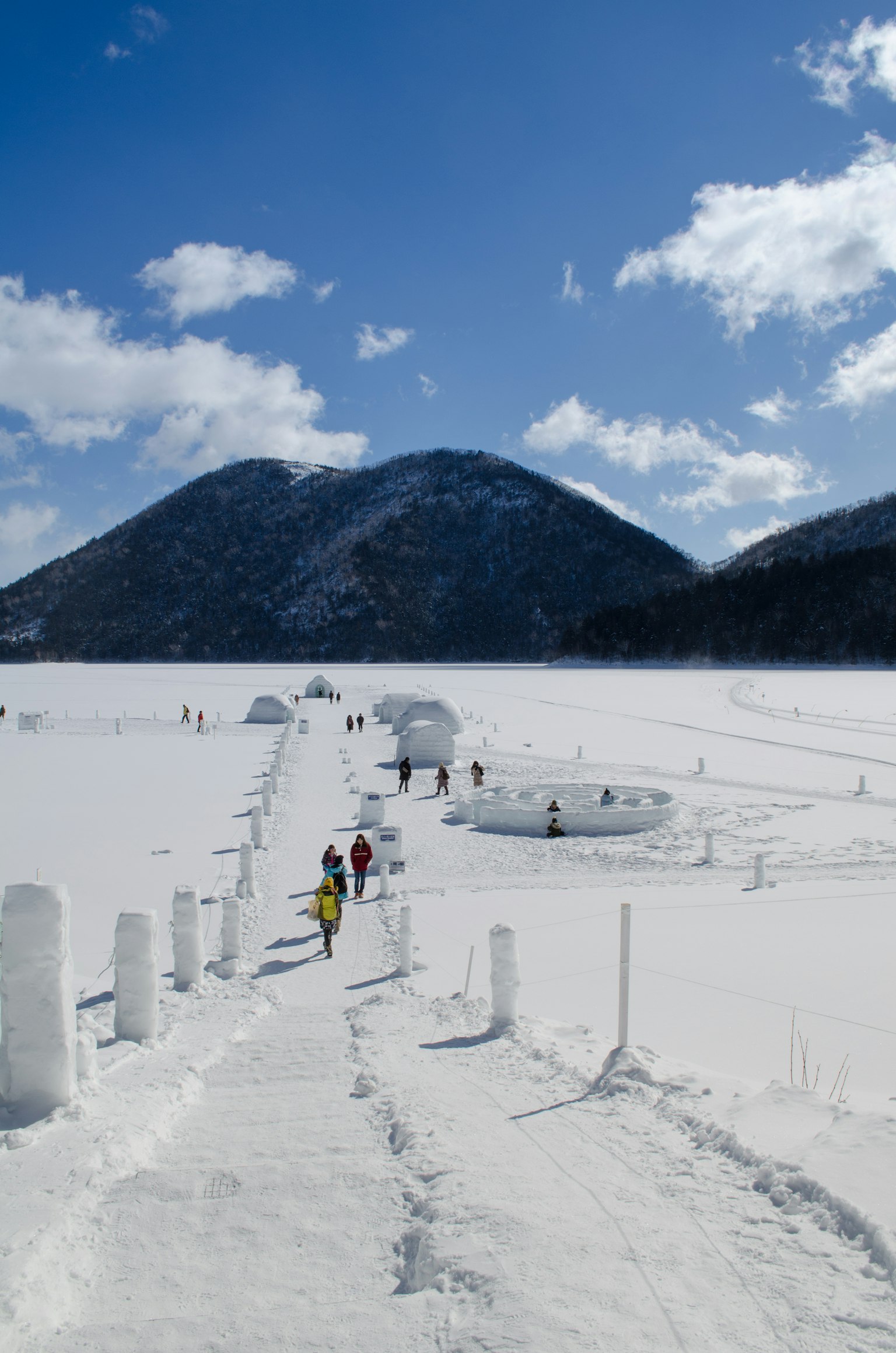 人們在雪地中行走，背景是山脈
