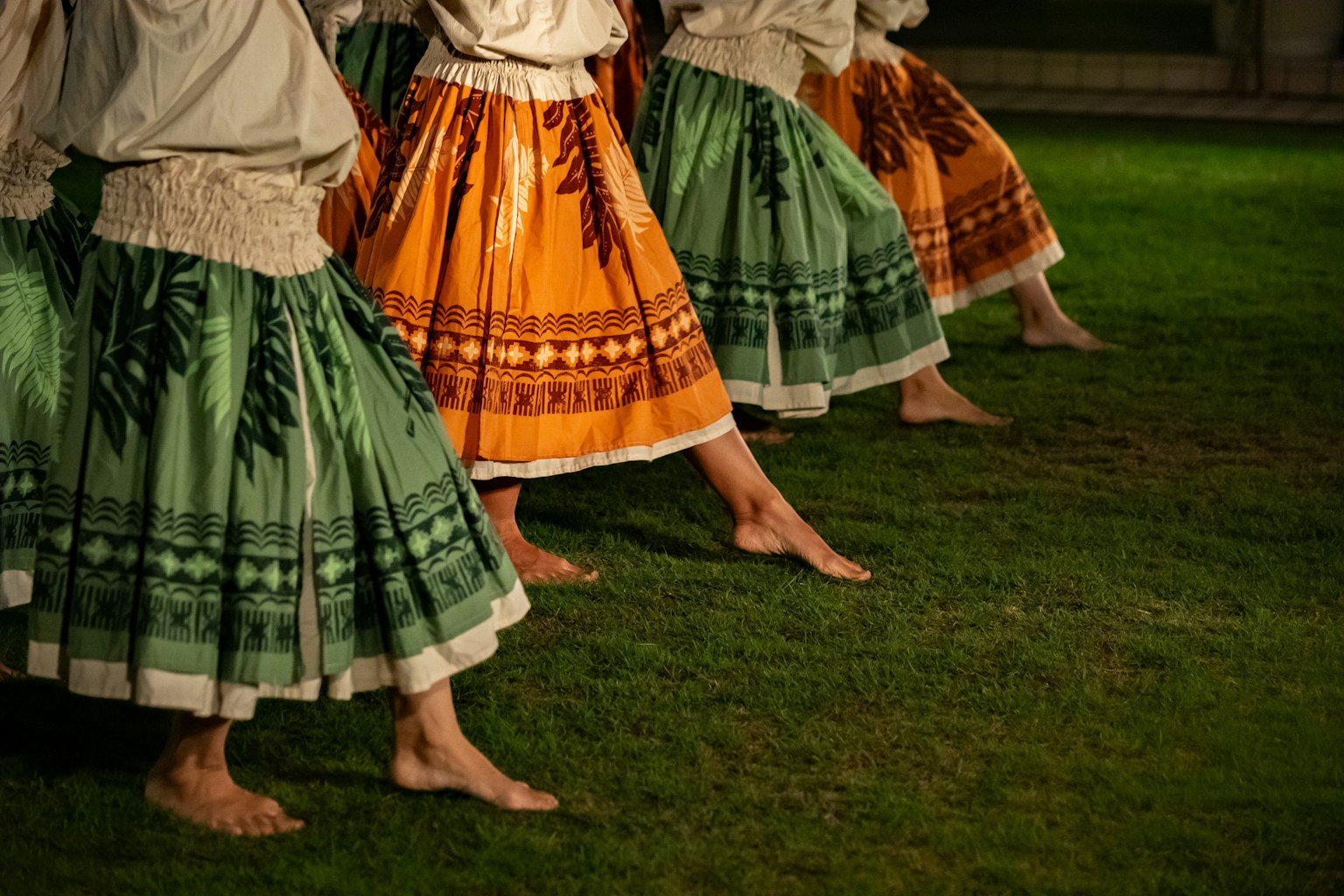 ハワイの伝統的なフラダンスの衣装を着た踊り手たちの足元のアップ