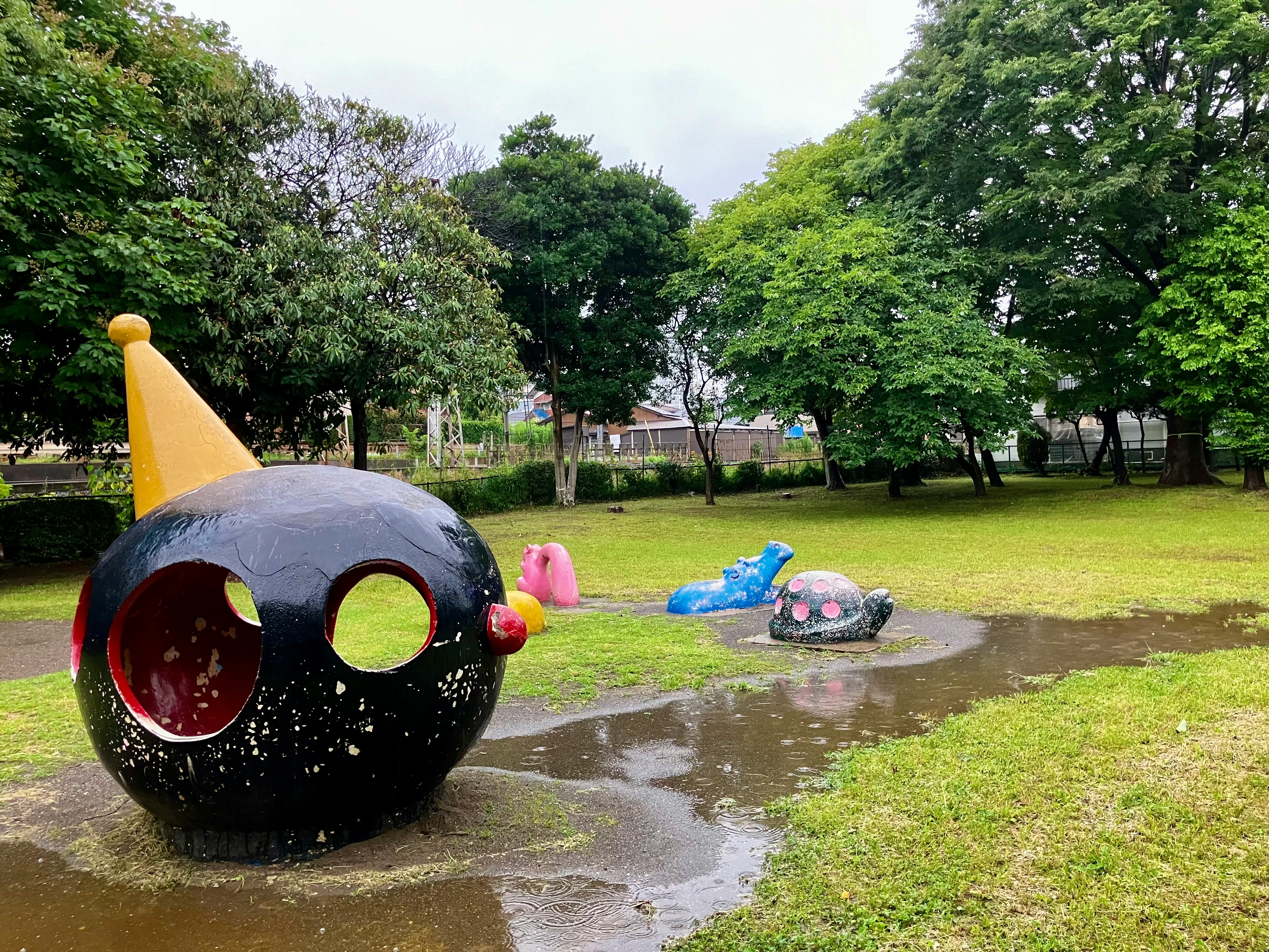 雨後公園裡彩色遊樂玩具漂在水窪中