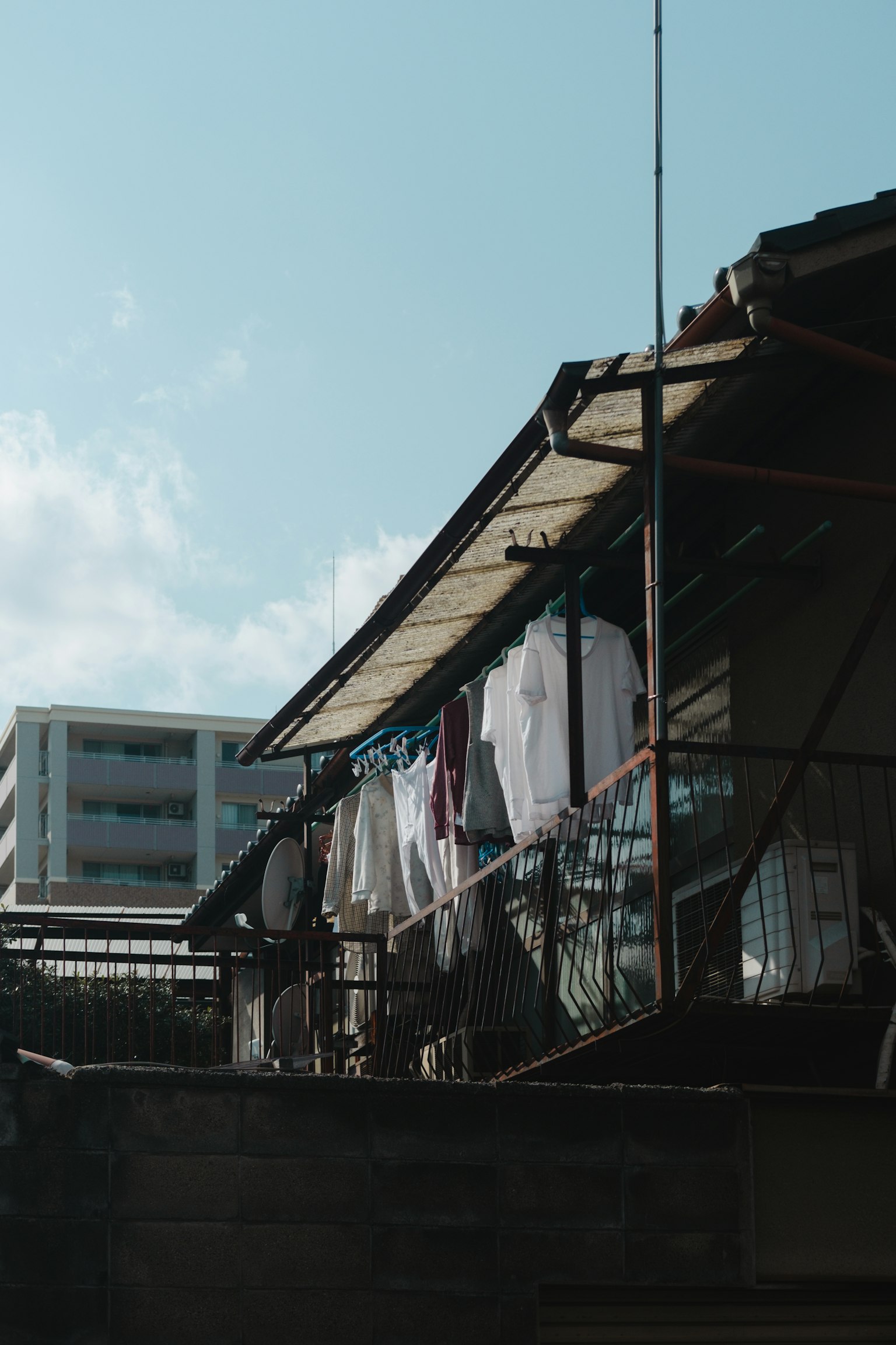 อาคารที่มีเสื้อผ้าตากอยู่ใต้ท้องฟ้าสีฟ้า
