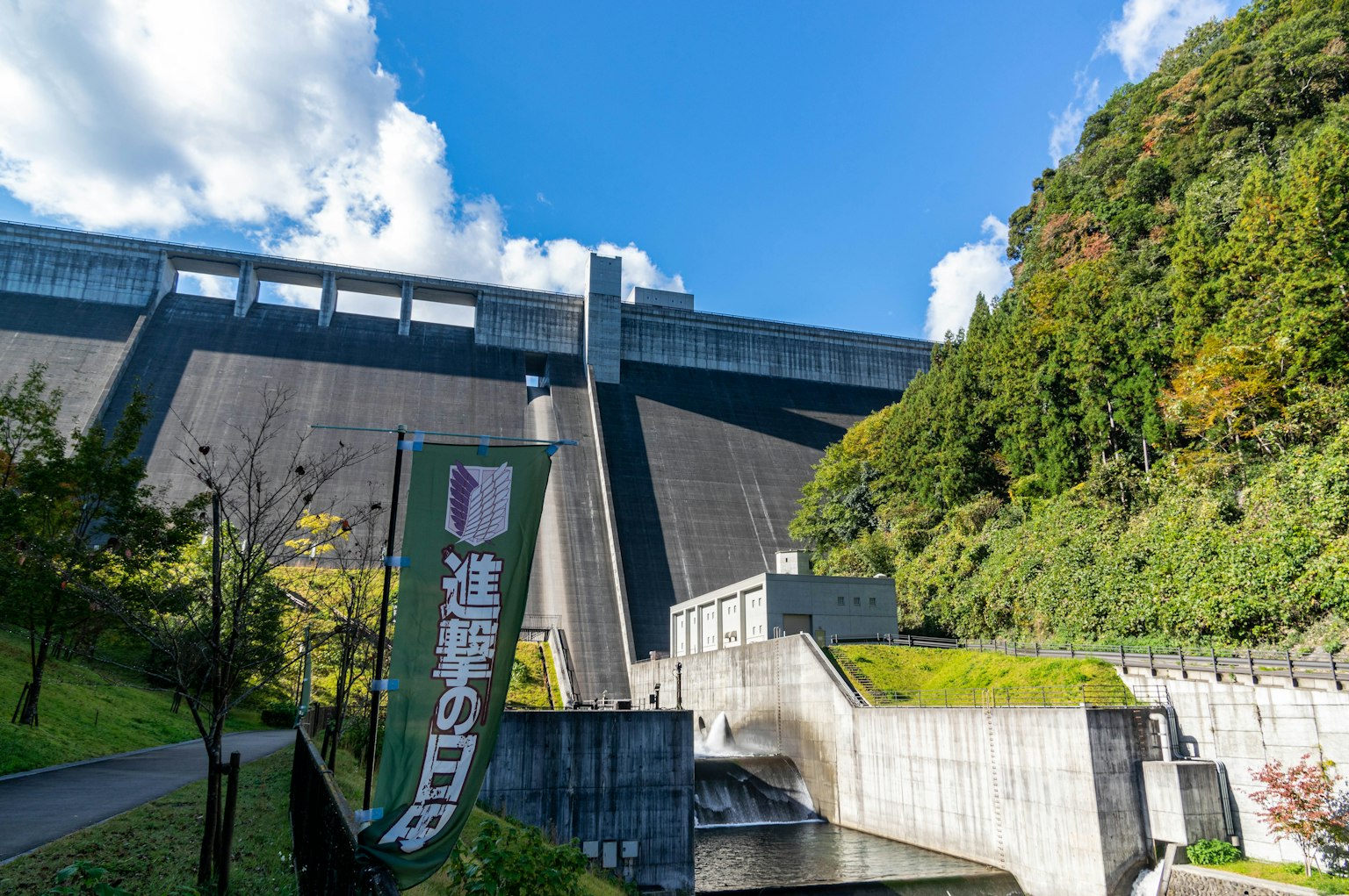 Gran represa con cielo azul y vegetación que presenta un letrero
