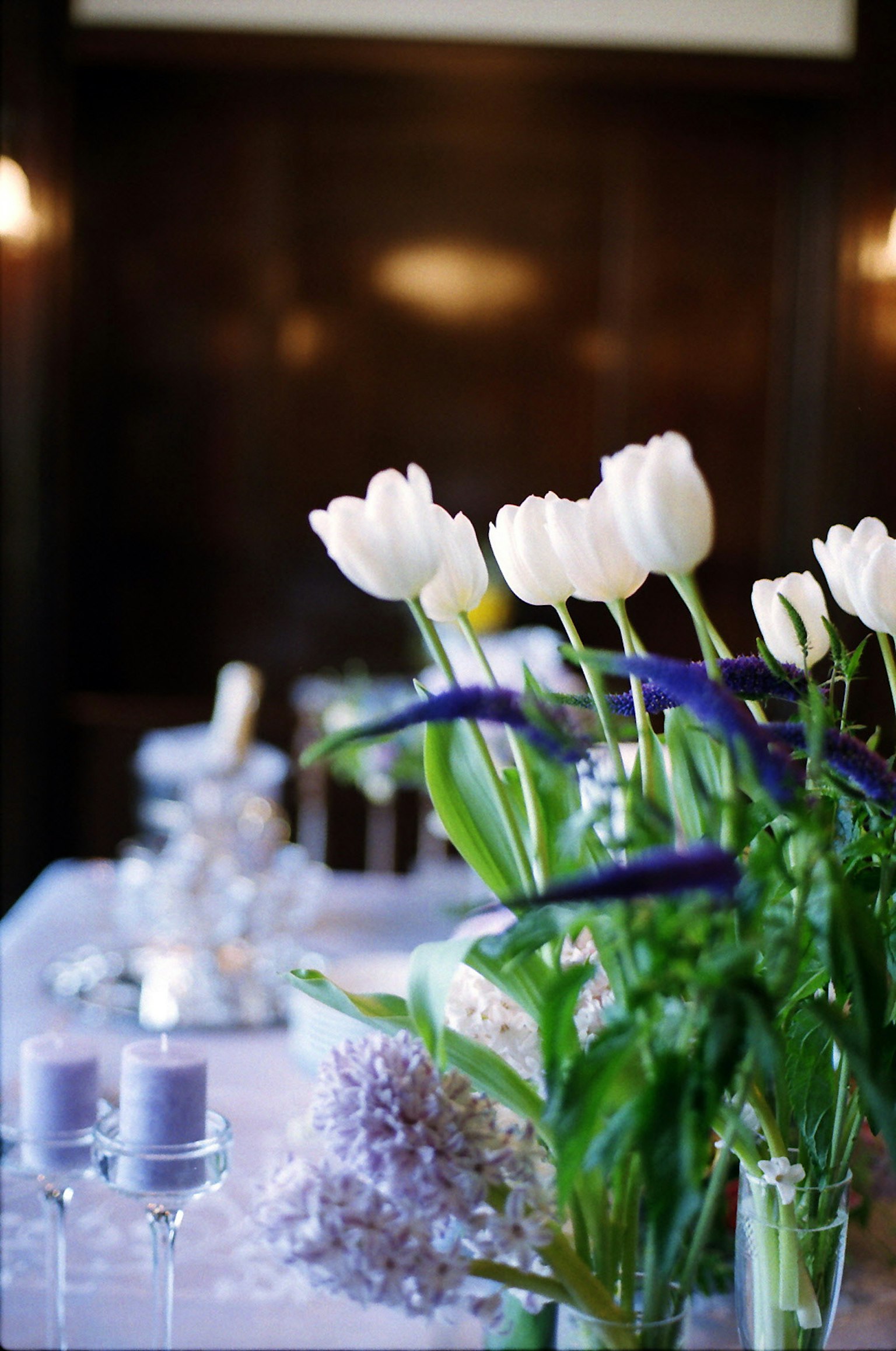 Arrangement de table avec des tulipes blanches et des fleurs violettes