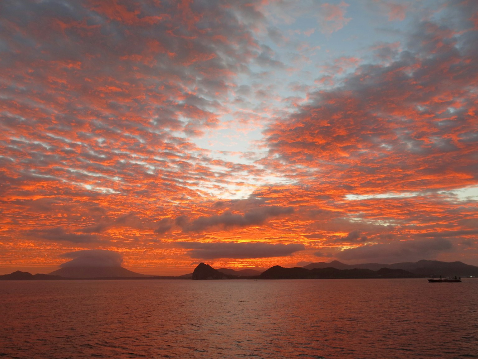 Sonnenuntergangshimmel über dem Meer mit roten und orangenen Wolken