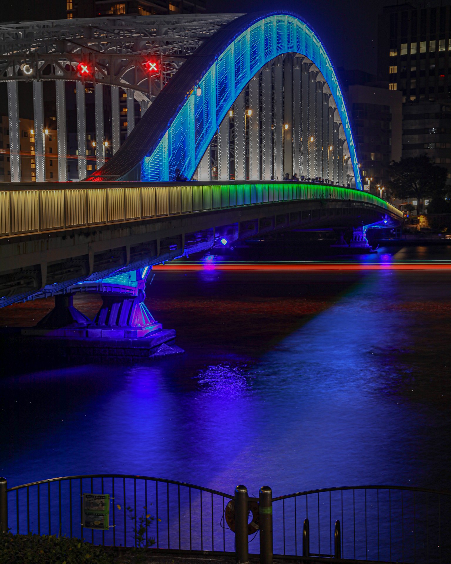 Ponte ad arco colorato illuminato di notte su un fiume
