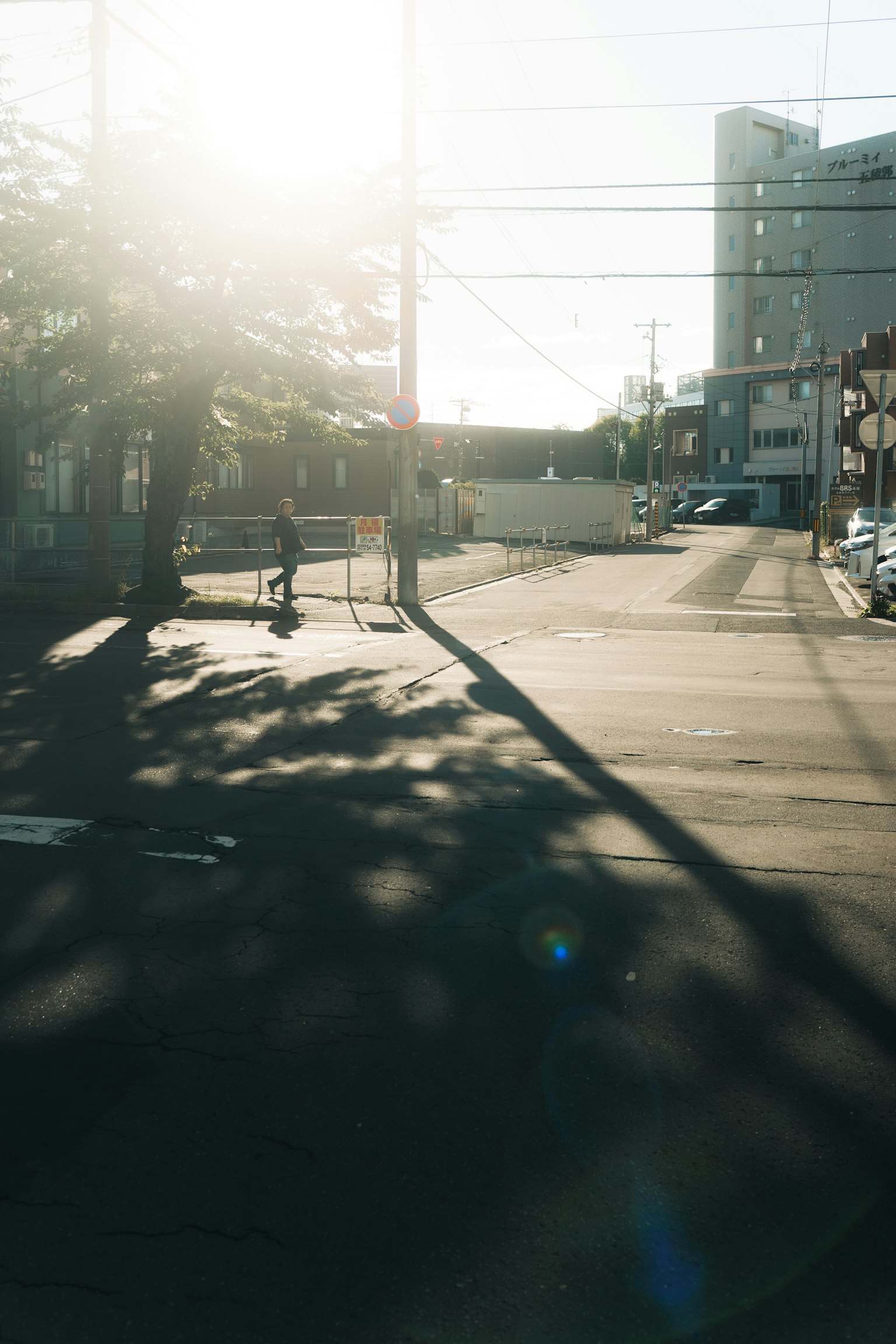 Menschen, die an einer ruhigen Straßenecke unter hellem Sonnenlicht gehen