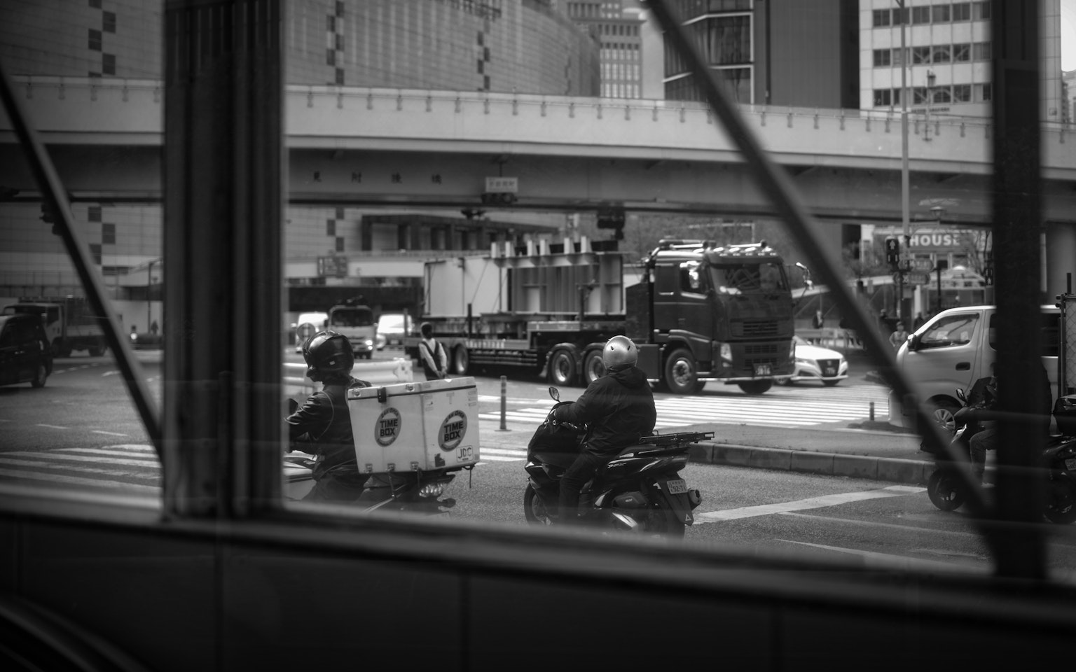 Intersection de ville en noir et blanc avec des motos et un camion