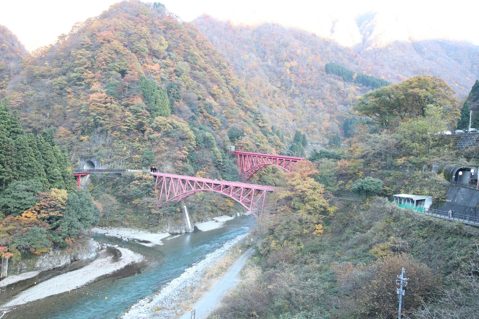 Vista pintoresca con puentes rojos rodeados de montañas de colores otoñales