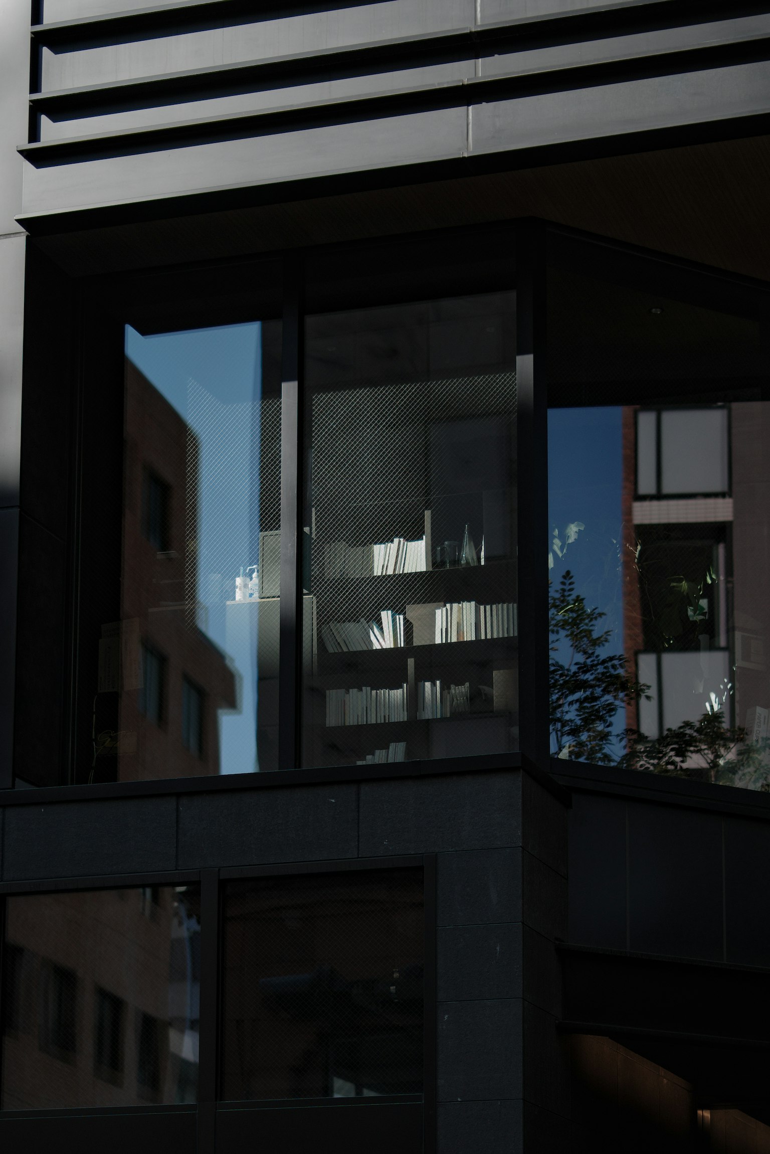 현대 건물의 창문과 주변 경관이 반사되고 있음