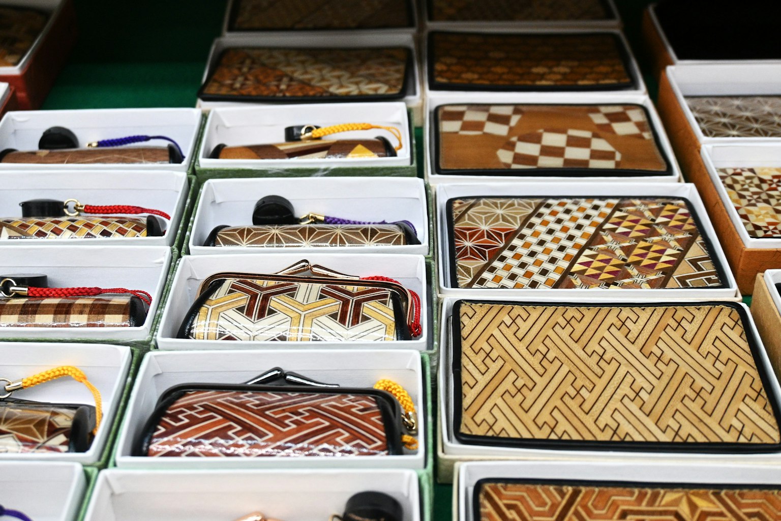 Eine Reihe von Geldbörsen mit verschiedenen komplizierten Mustern in Boxen ausgestellt