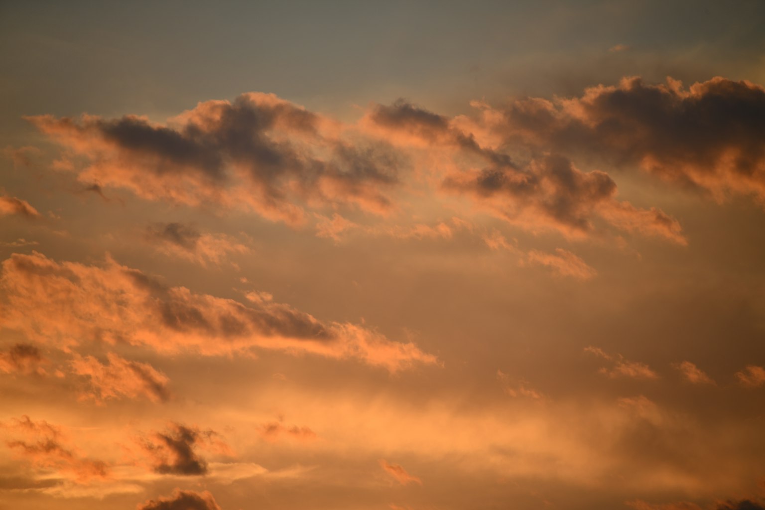 Langit dipenuhi awan oranye saat matahari terbenam