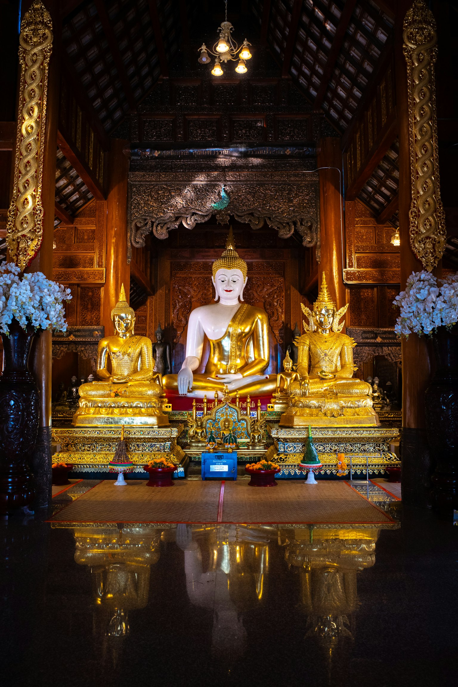 Vista interior de un templo con estatuas de Buda doradas