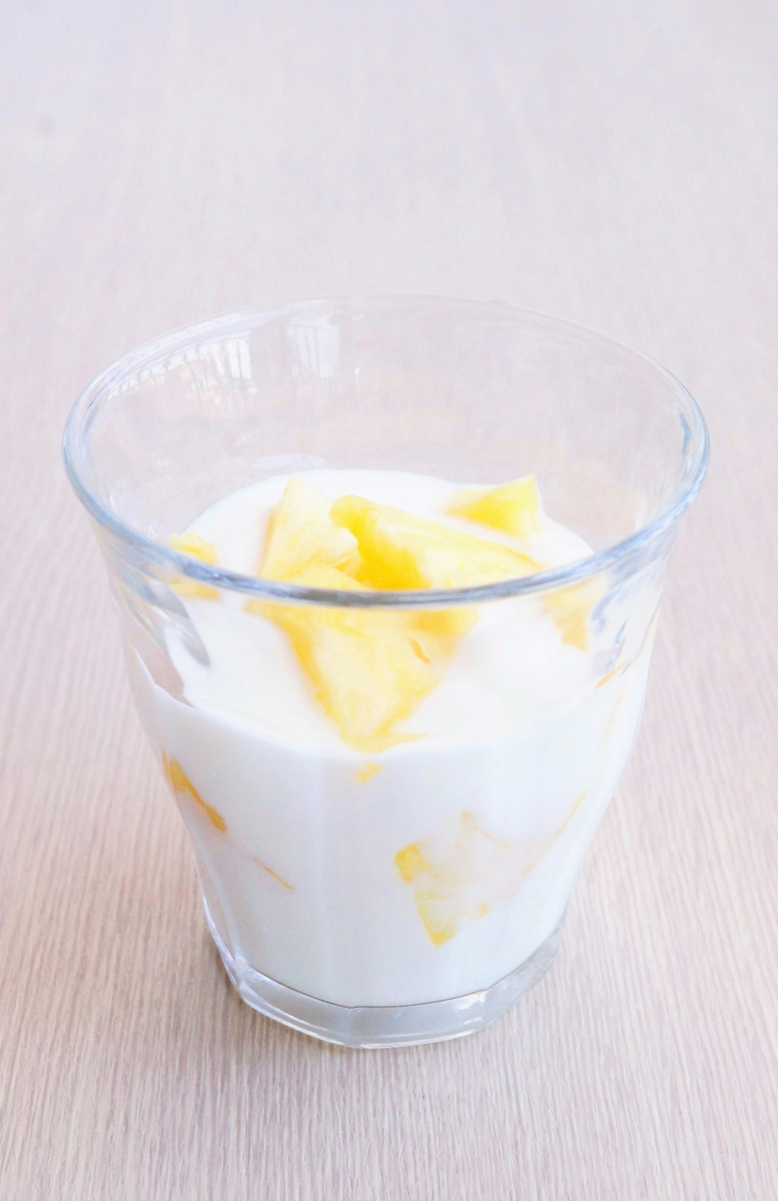 Una taza de vidrio con yogur y rodajas de mango