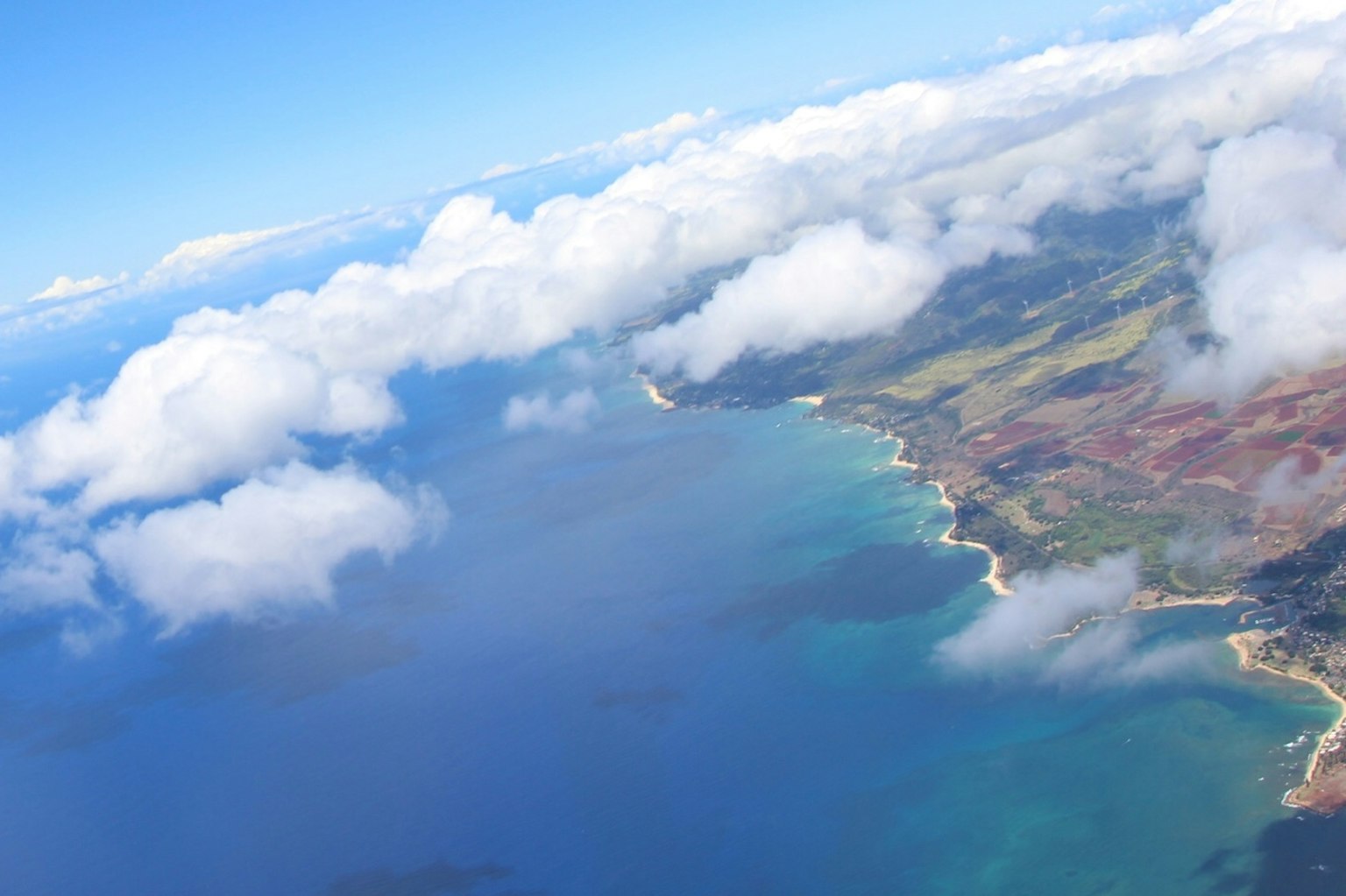 Vue aérienne de l'océan bleu avec des nuages et une côte verdoyante