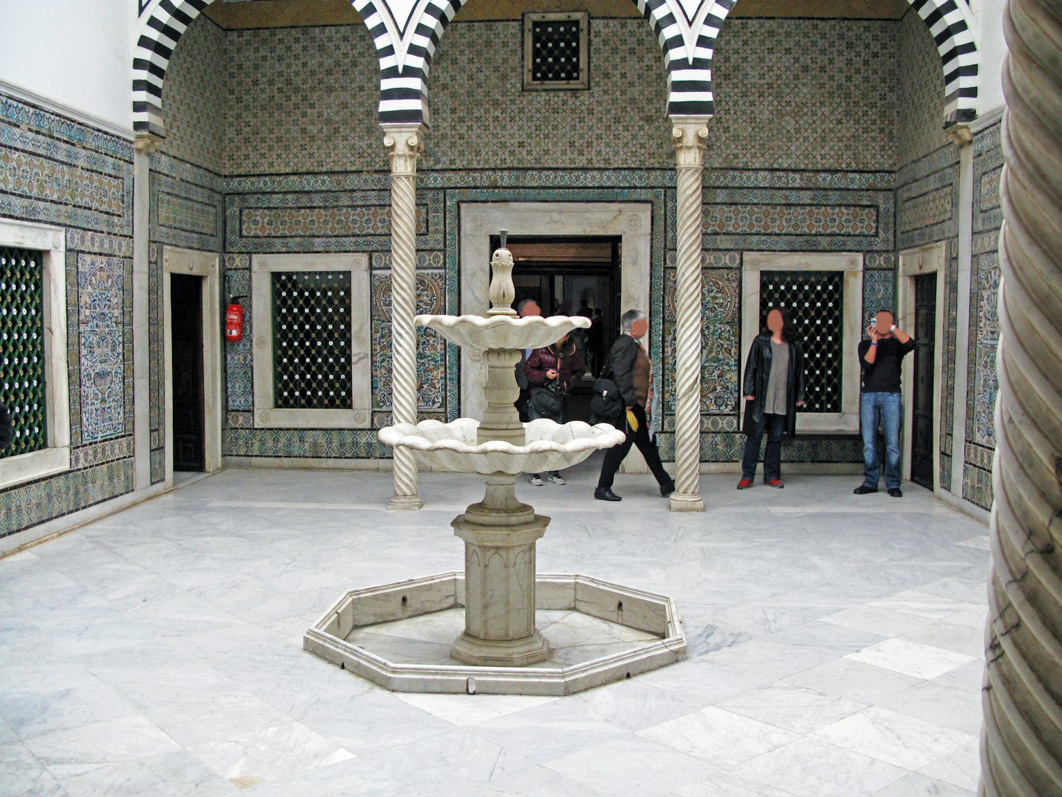 Ein schöner Innenhof mit einem Brunnen und dekorativen gefliesten Wänden