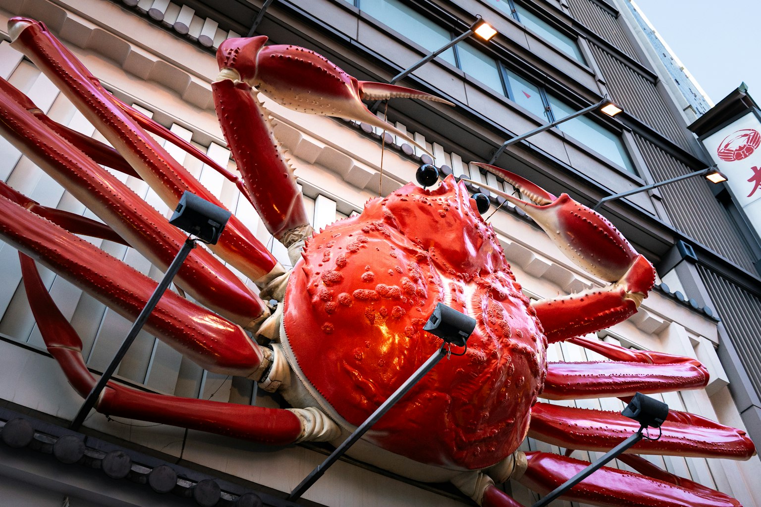 A large red crab sign mounted on the exterior wall of a building