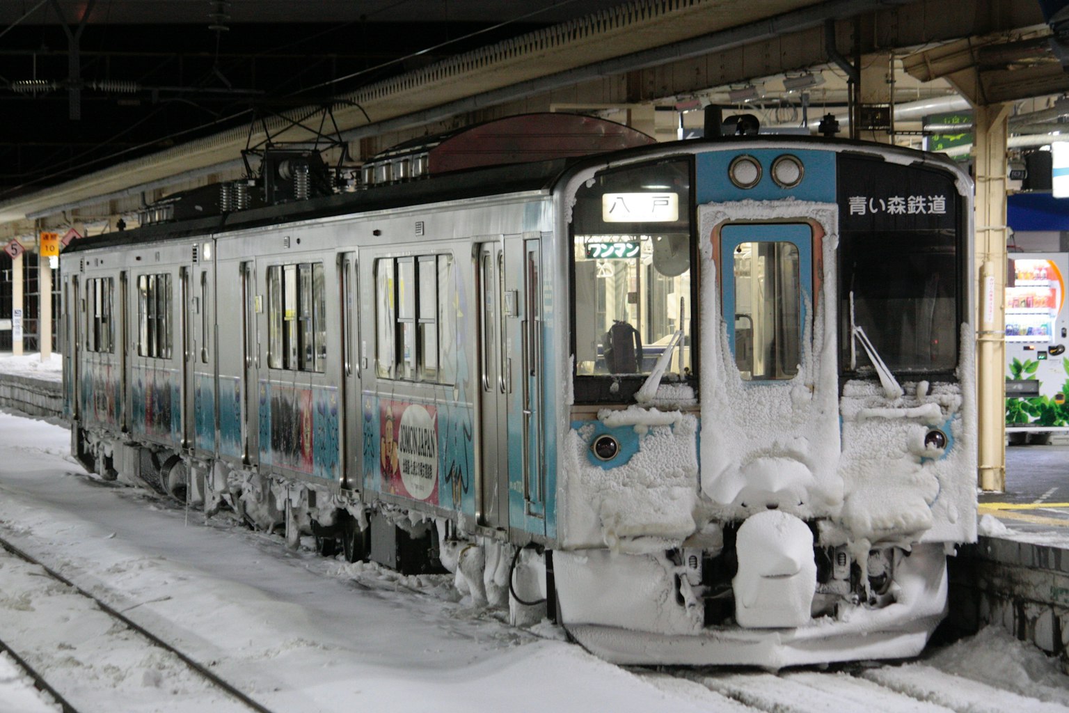 Un tren cubierto de nieve estacionado en una estación