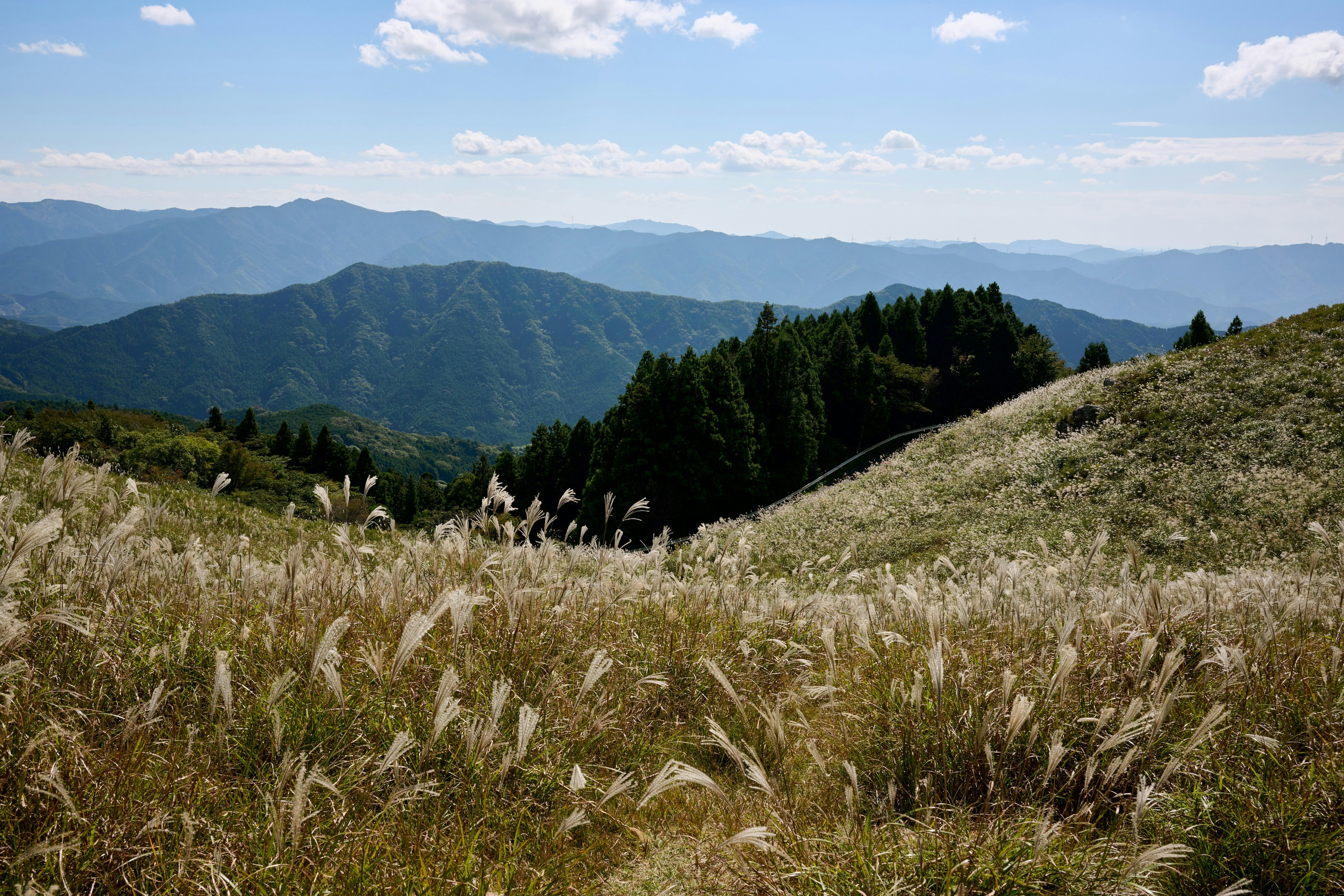 山稜と草原の向こうに連なる山並みの景色