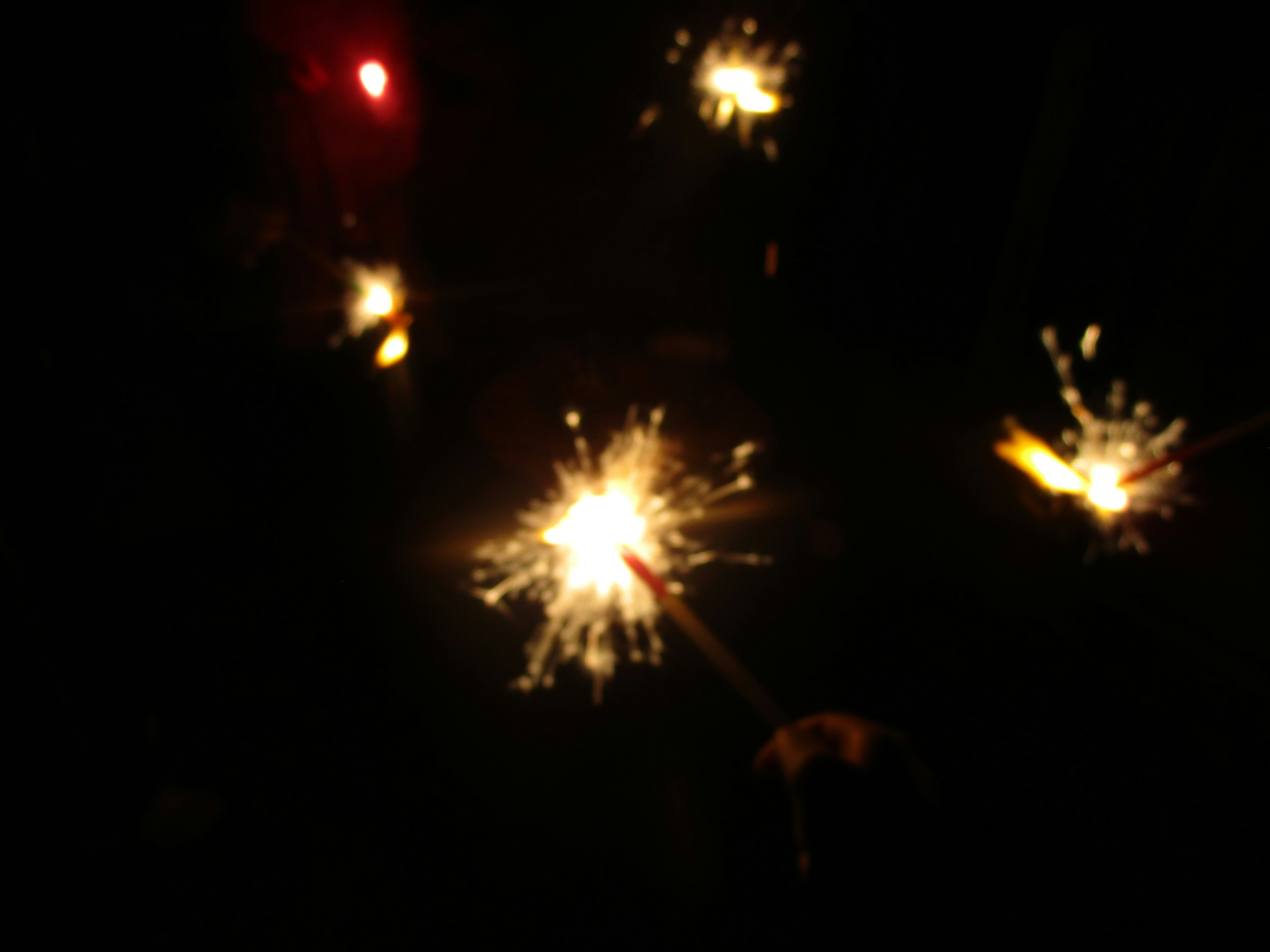 夜の暗闇で光る花火の火花が飛び散る様子