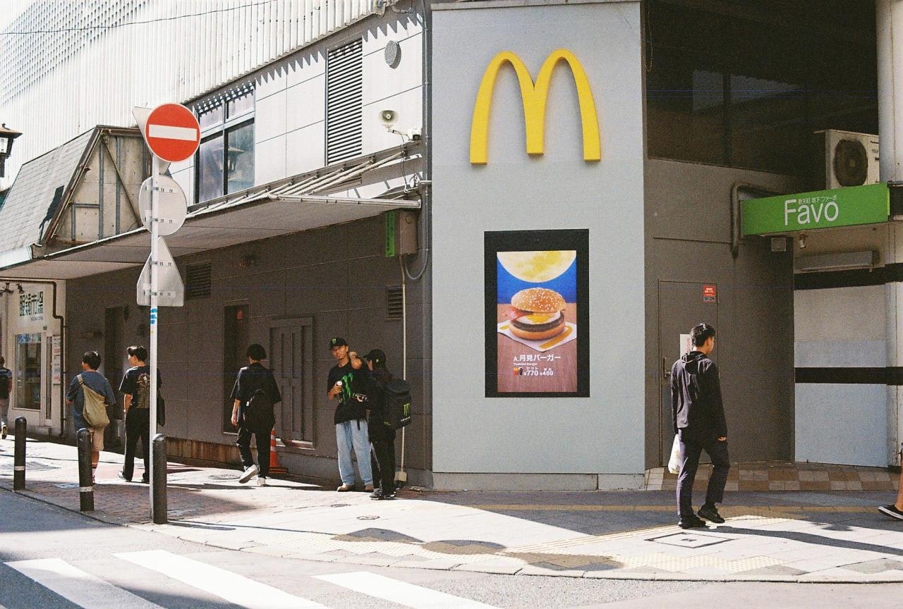 マクドナルドの看板がある都市の路地の歩道