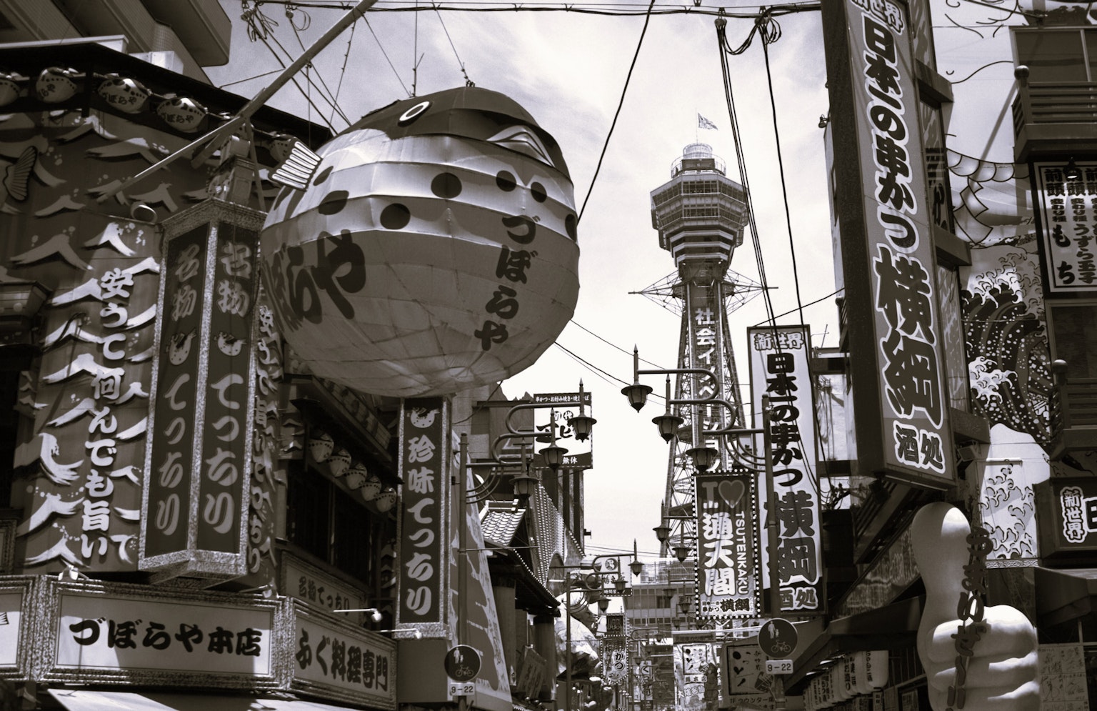 黑白街景，大灯笼和餐馆招牌，背景是通天阁