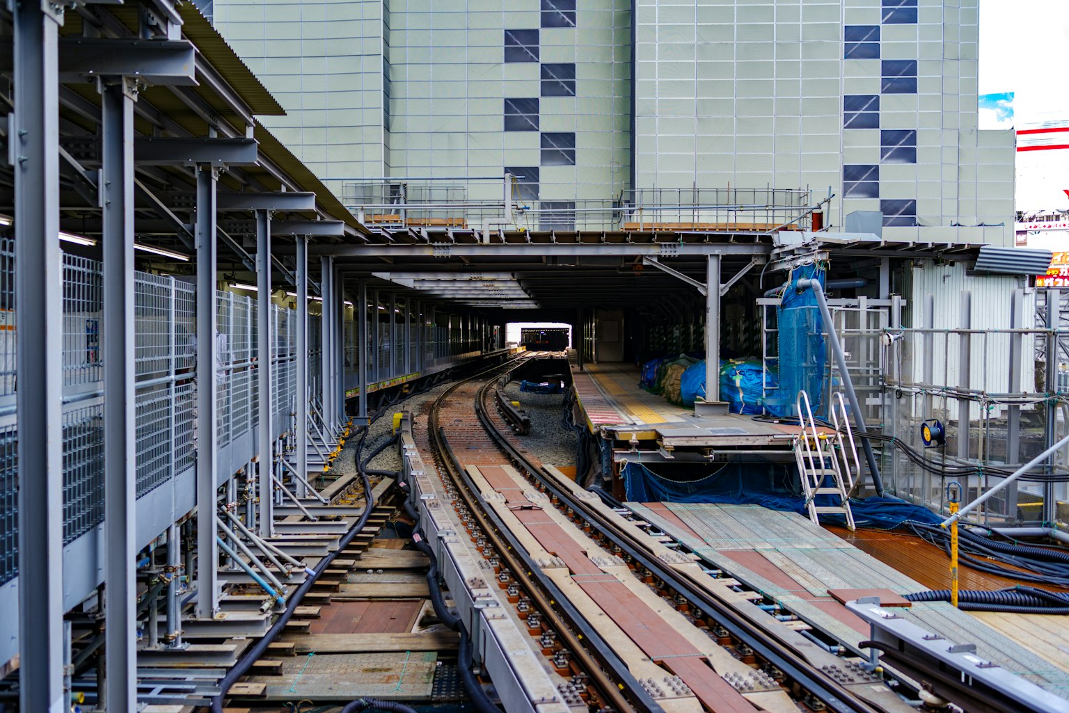 Vue intérieure d'une plateforme de gare avec des voies ferrées visibles