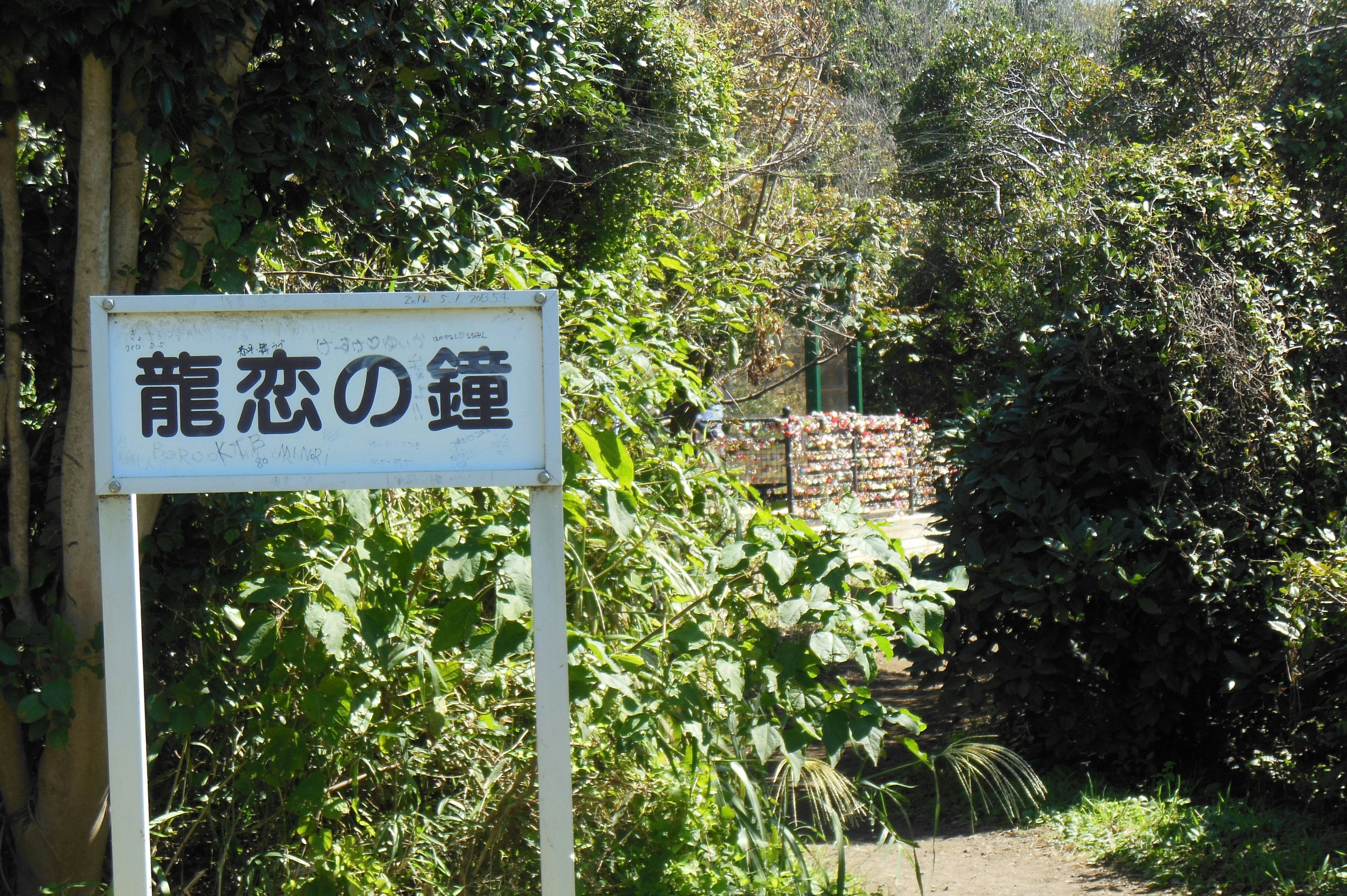 绿意环绕的“龙恋の鐘”路牌旁小径