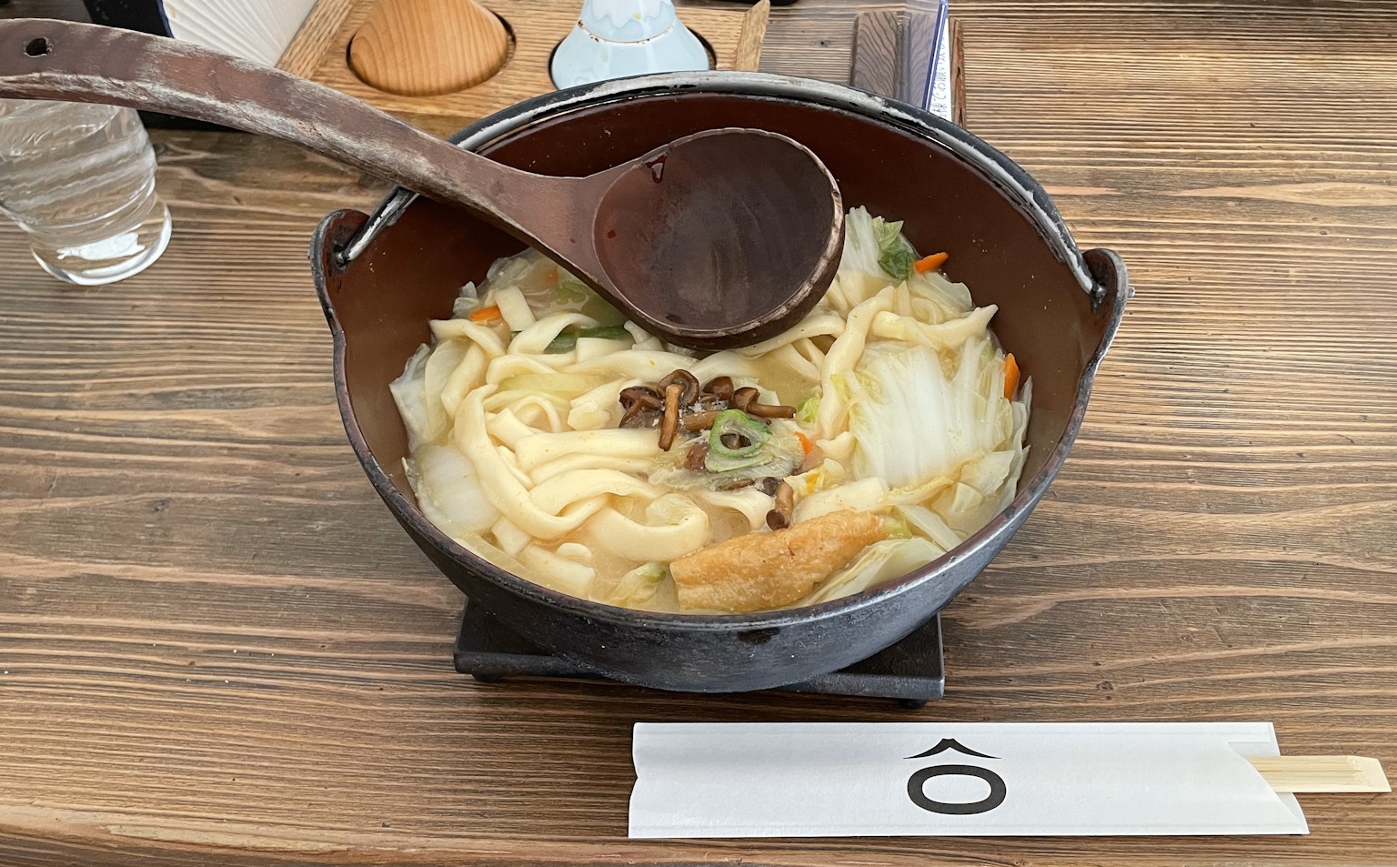 Warm udon noodle bowl with wooden spoon