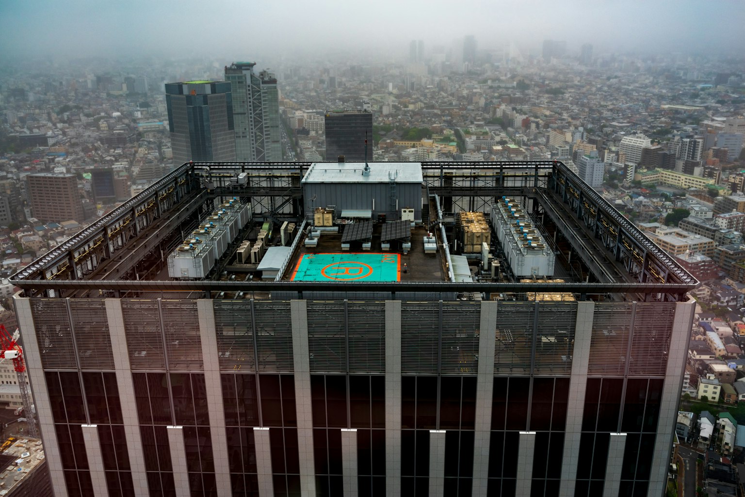 View from the rooftop of a skyscraper overlooking a foggy cityscape