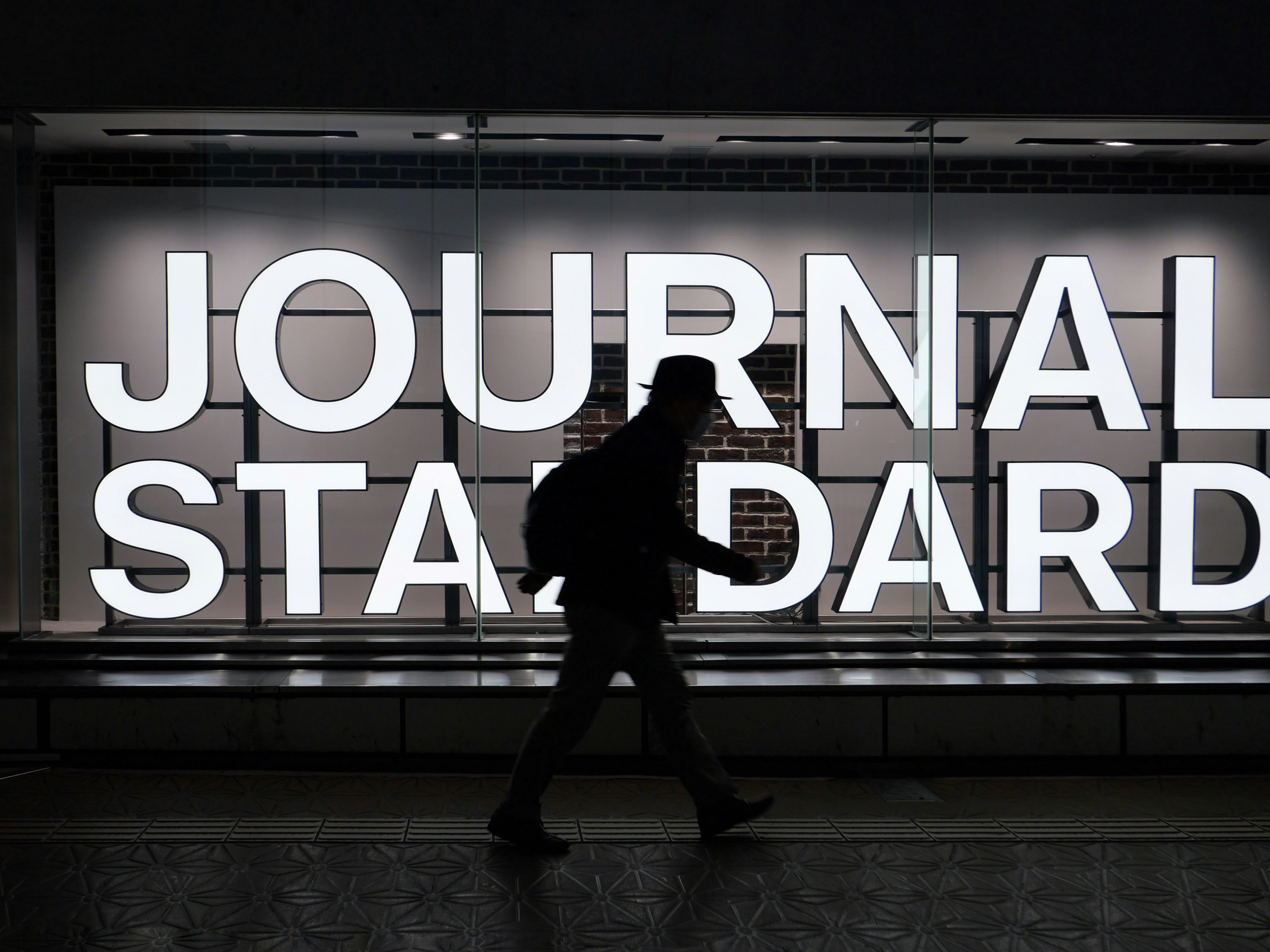 คนเดินผ่านป้าย “JOURNAL STANDARD”