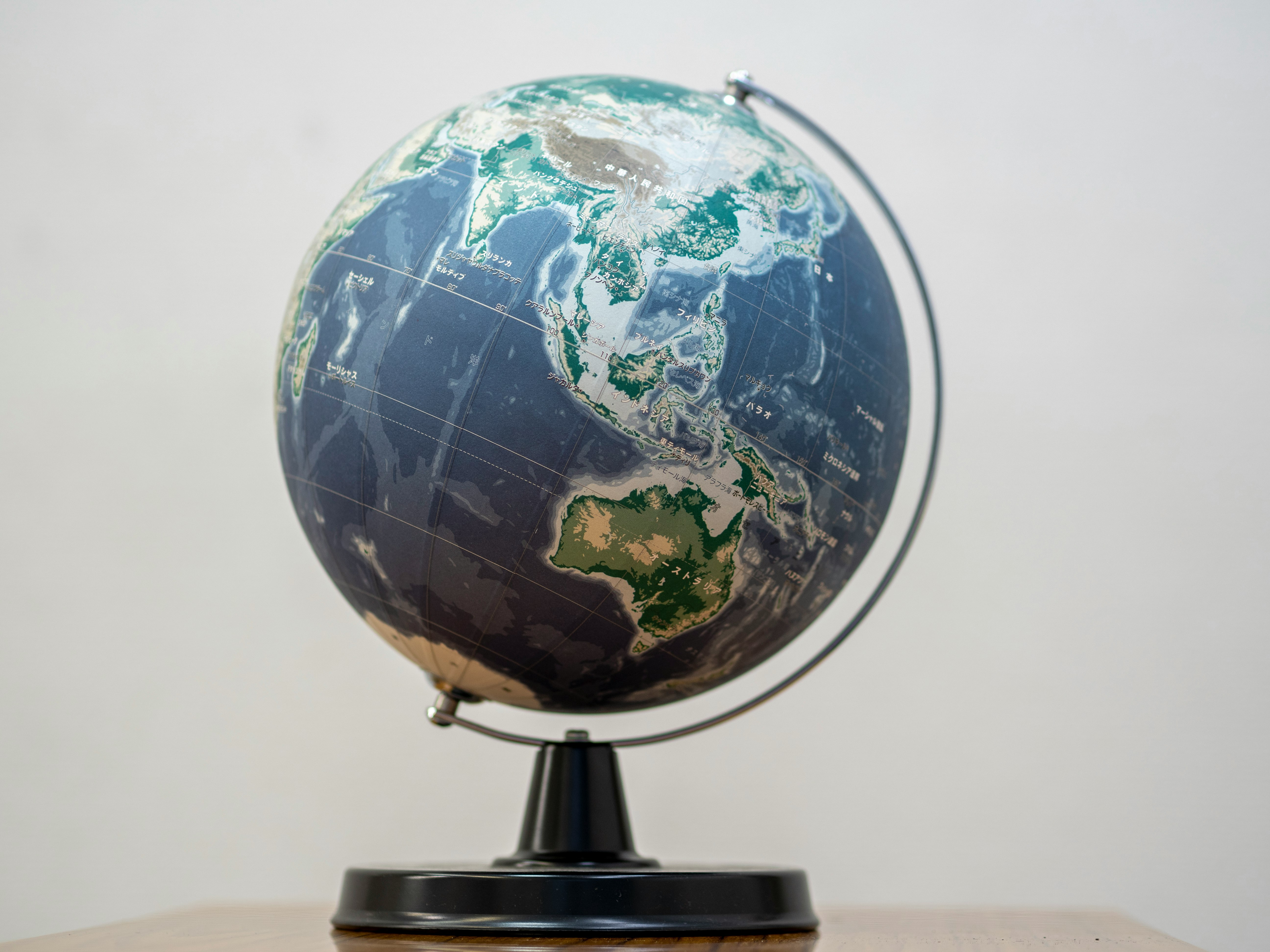 globo terráqueo sobre un escritorio con un mapa mundial