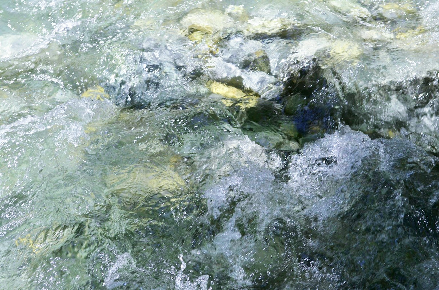 Image d'eau claire montrant des pierres et des bulles sous la surface