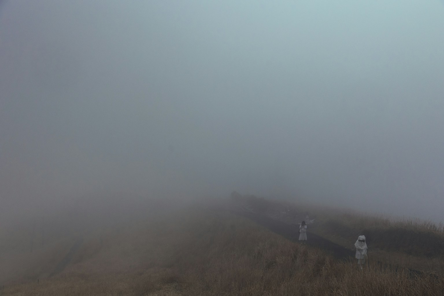 Foggy landscape with silhouettes of distant people