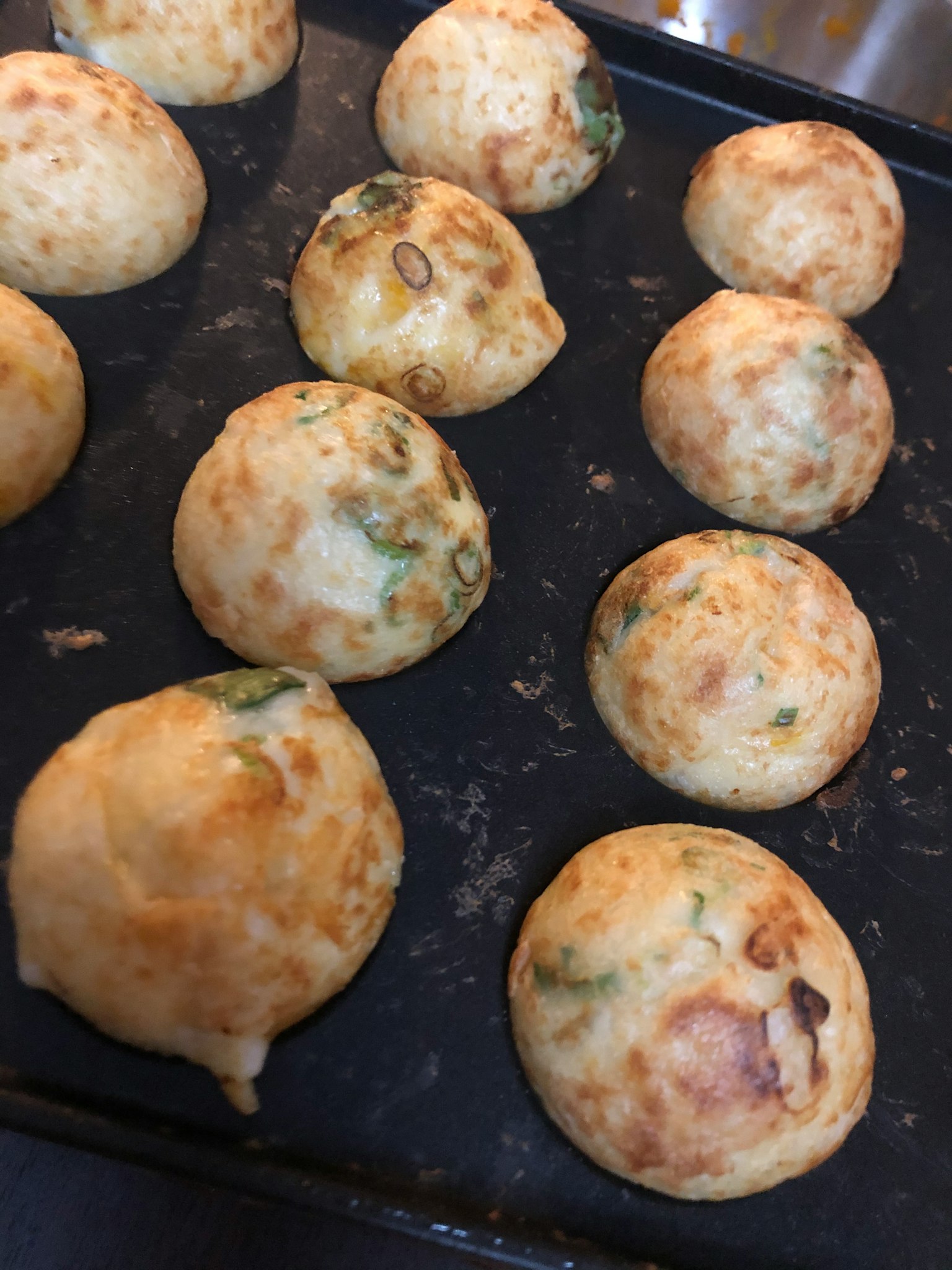 Palline di takoyaki appena cotte disposte su un vassoio