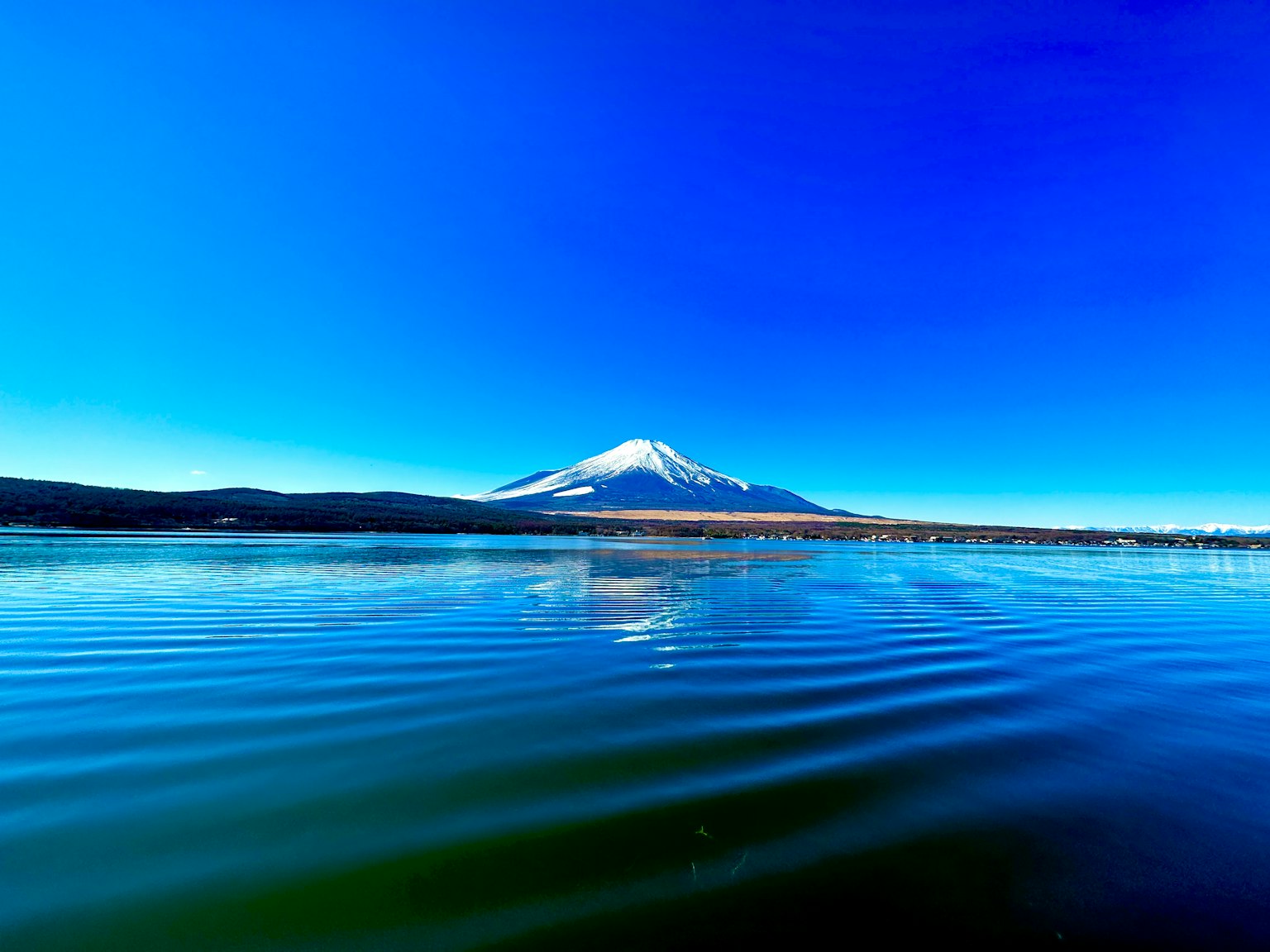 Schöne Landschaft des Fuji-Berges vor einem blauen Himmel mit Wasserwellen