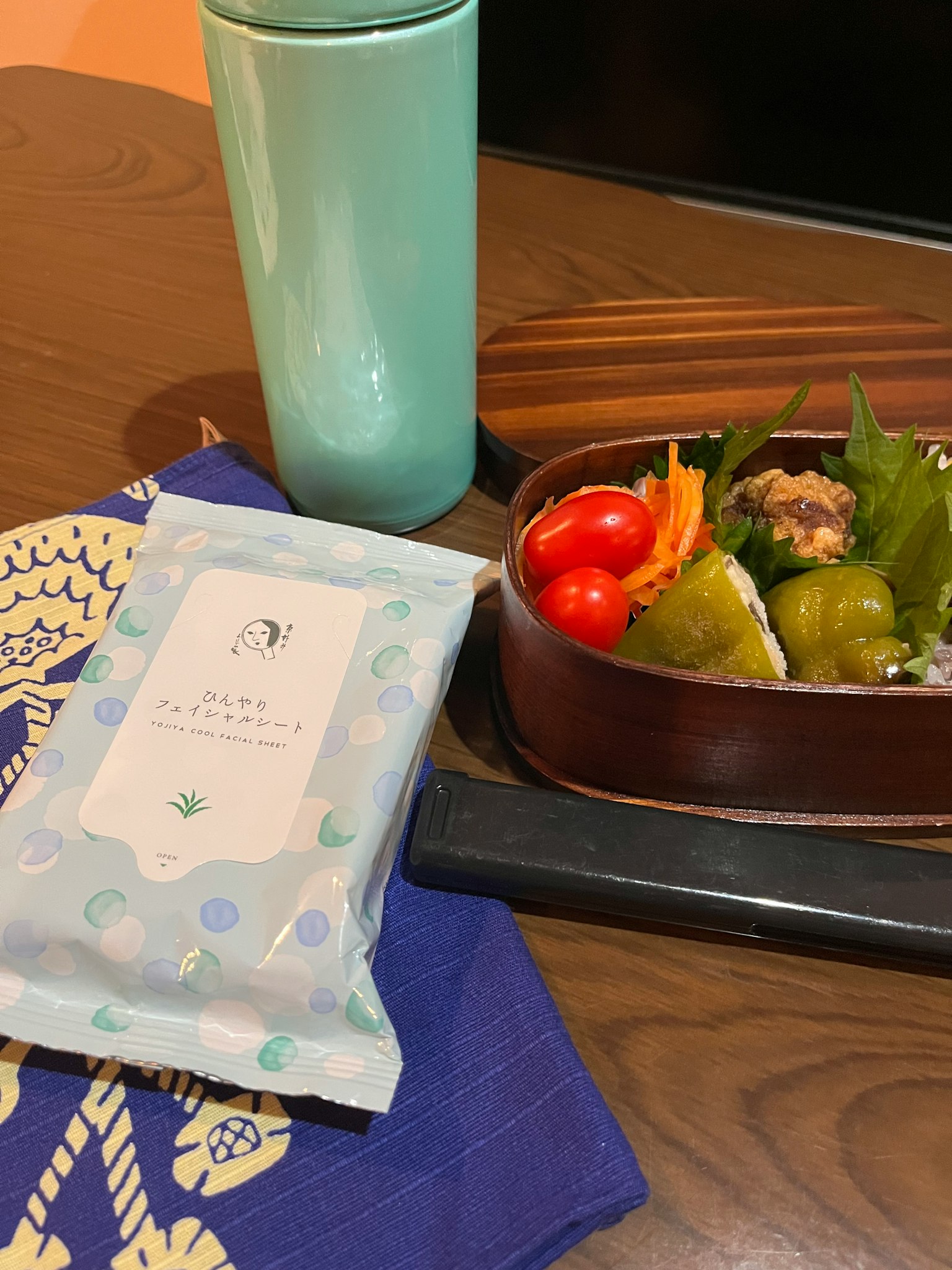 Kotak bento dengan sayuran berwarna-warni dan minuman di atas meja