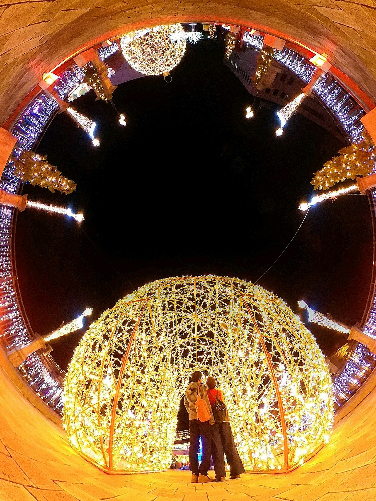 Silhouette of a couple expressing love amidst glowing lights at night