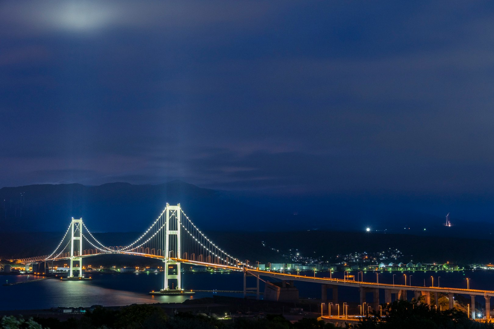 夜の海とライトアップされた吊り橋の眺め