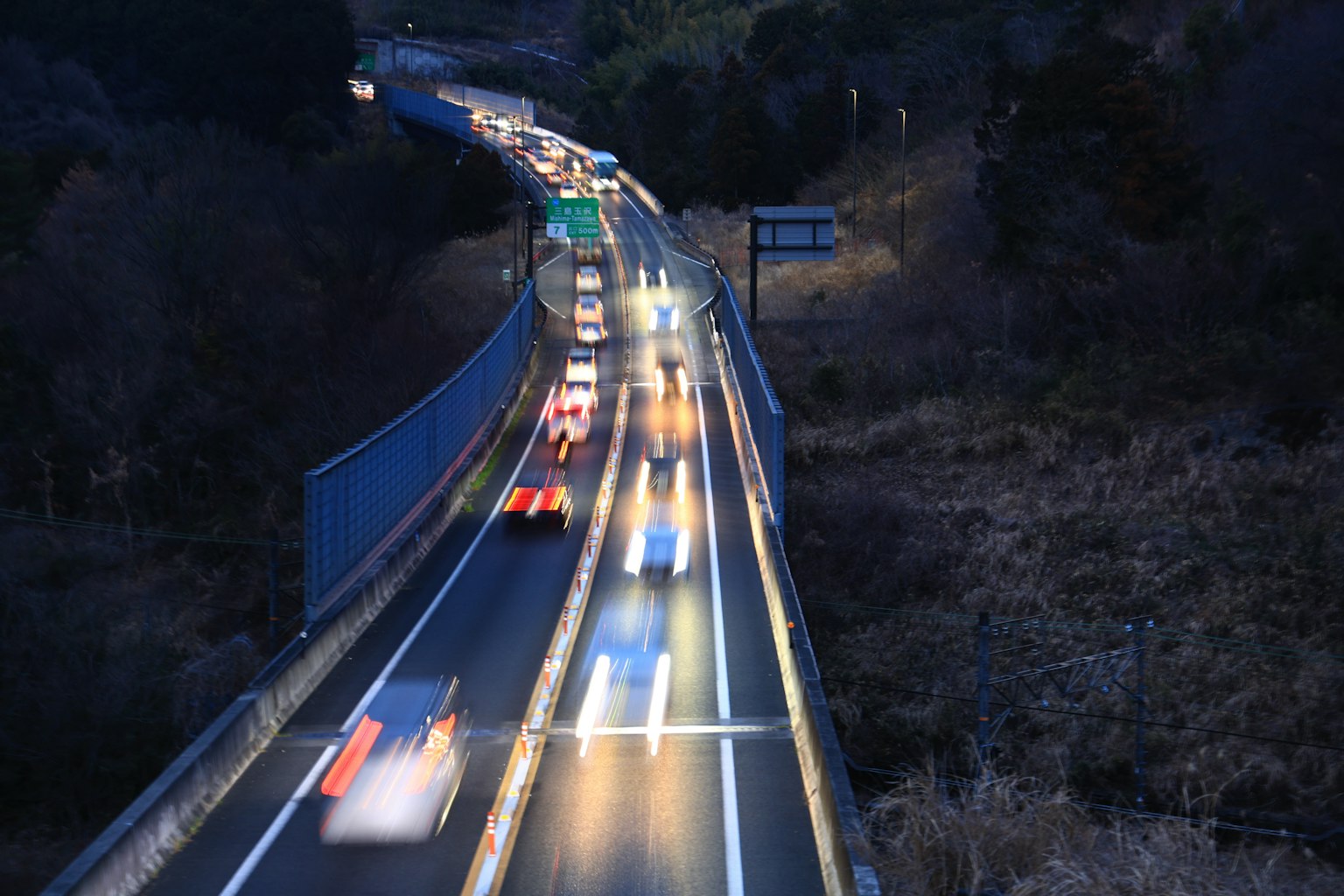 Trails lumineux de voitures sur une autoroute la nuit
